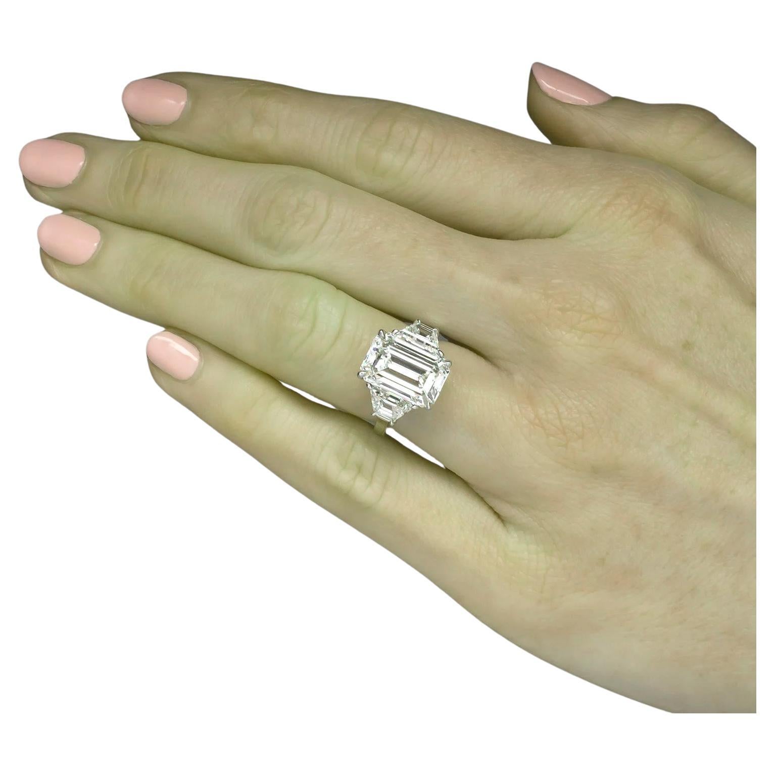 This magnificent ring showcases a GIA certified 5.01 carat emerald cut diamond, elegantly set in a polished platinum band for timeless sophistication. 

Displaying an E color grade, the diamond achieves a colorless beauty, enhancing its vibrant
