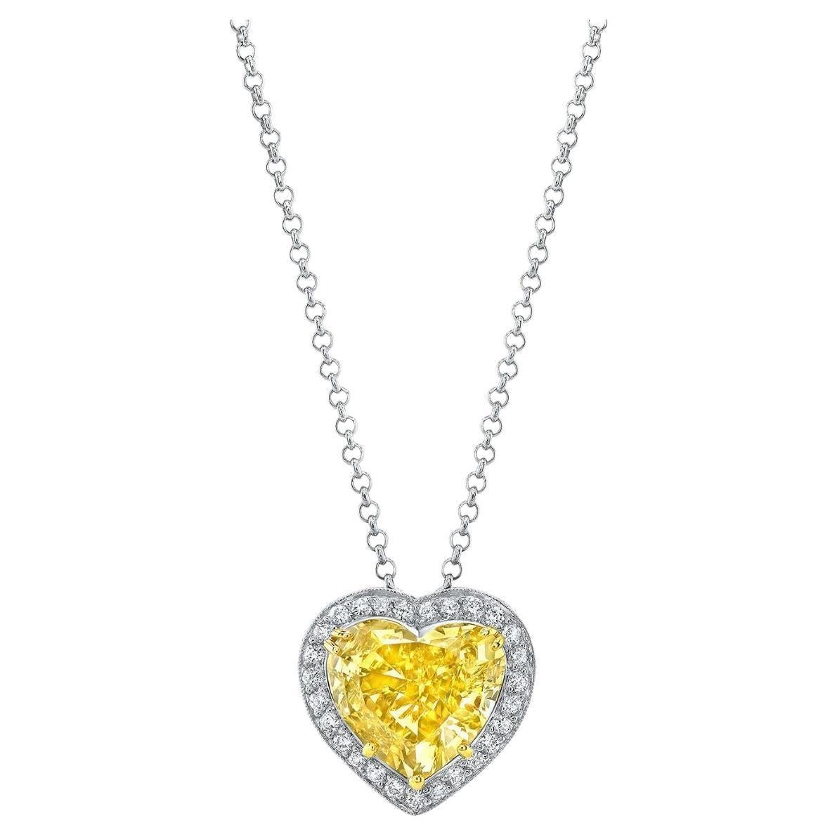 A platinum pendant showcasing exquisite craftsmanship, featuring a 5.08-carat Fancy Brownish Yellow/VS2 GIA-certified Heart Shape Diamond at its center. Surrounding the captivating centerpiece are 27 Round Brilliant cut Diamonds, collectively