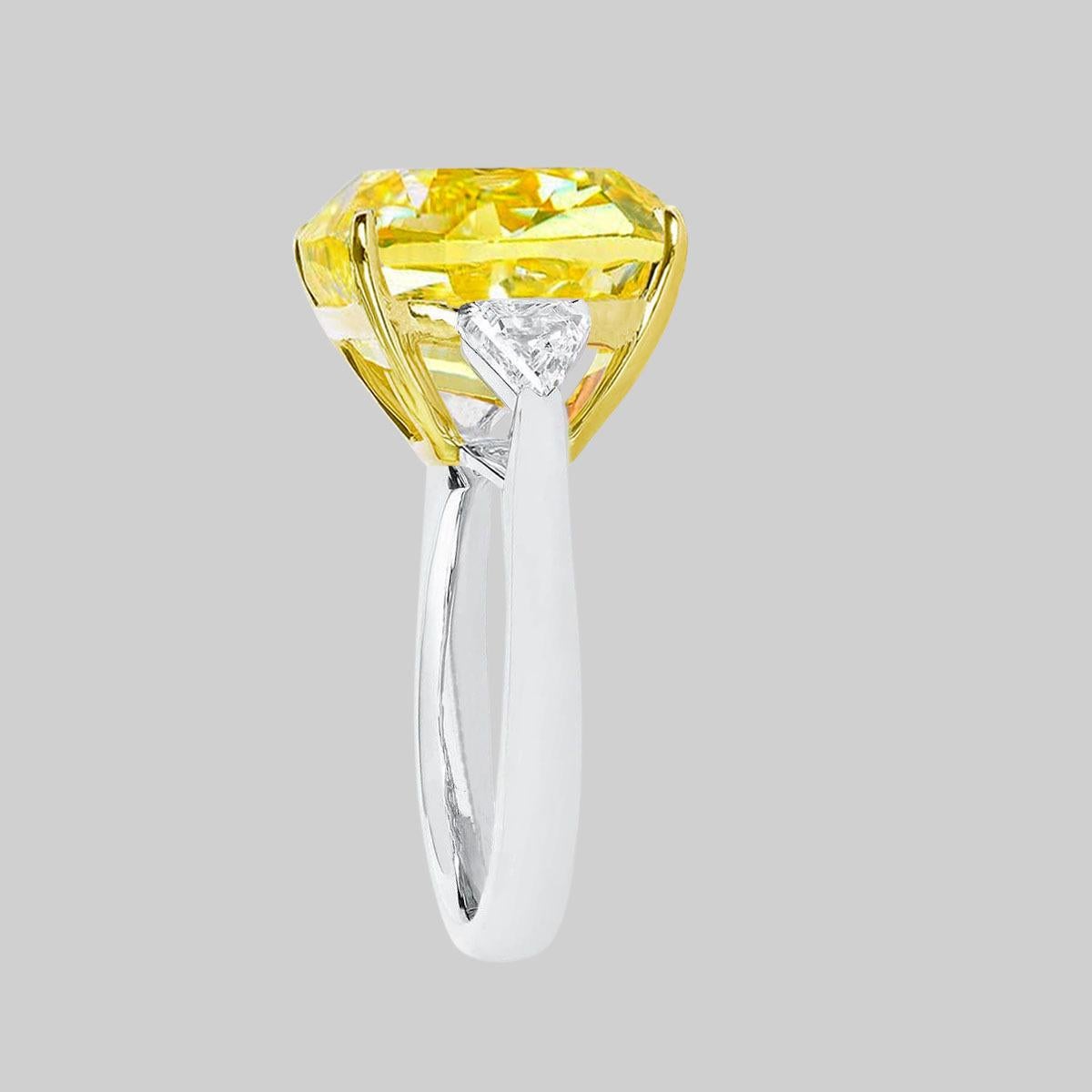 Stunning GIA certified fancy VIVID yellow cushion cut diamond ring with two side trillion natural diamonds at each side mounted in 18 carats yellow gold and white gold.

The main stone sparkle is a very strong yellow is a vivid color!



