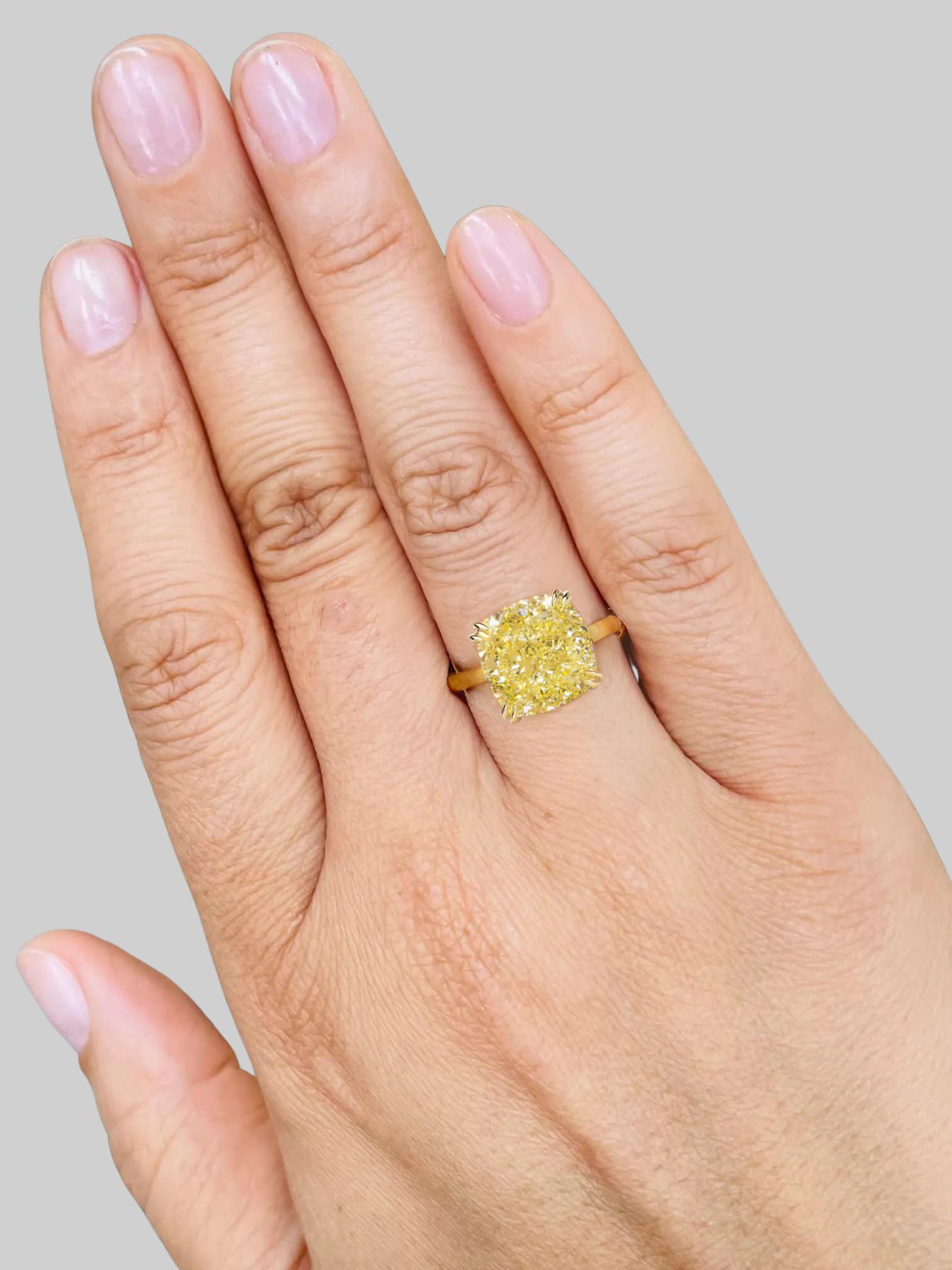 This stunning solitaire ring features a 5.01 carat fancy intense yellow Cushion Cut diamond, GIA certified for its exceptional quality. 

Crafted in 18K yellow gold, the warm hue of the setting beautifully complements the vibrant color of the