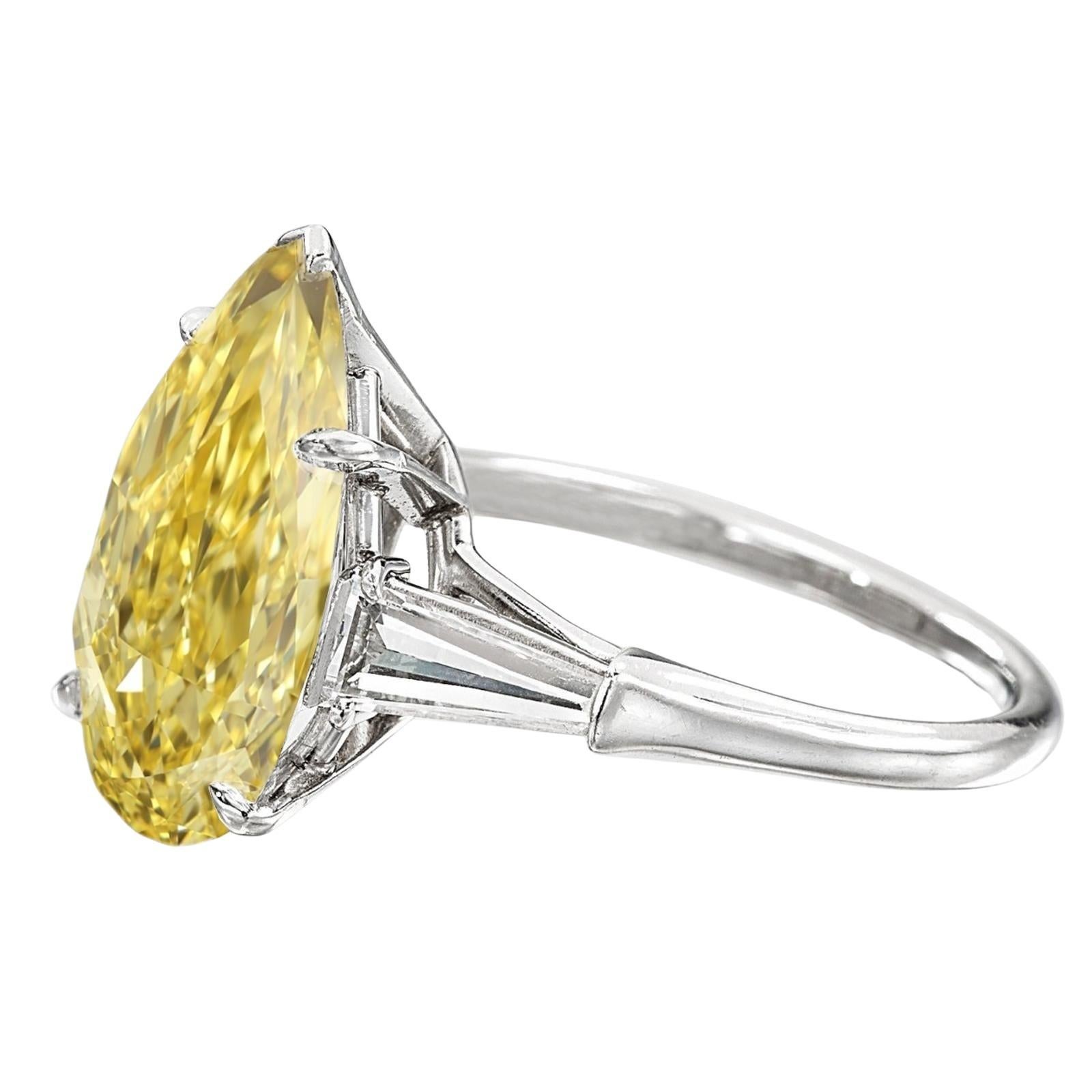 This exquisite ring by Cecile Blake is crafted in platinum and features a breathtaking 5-carat fancy light yellow pear-cut diamond, certified by GIA. The vibrant center stone is accented by two tapered baguette diamonds, adding a sophisticated touch