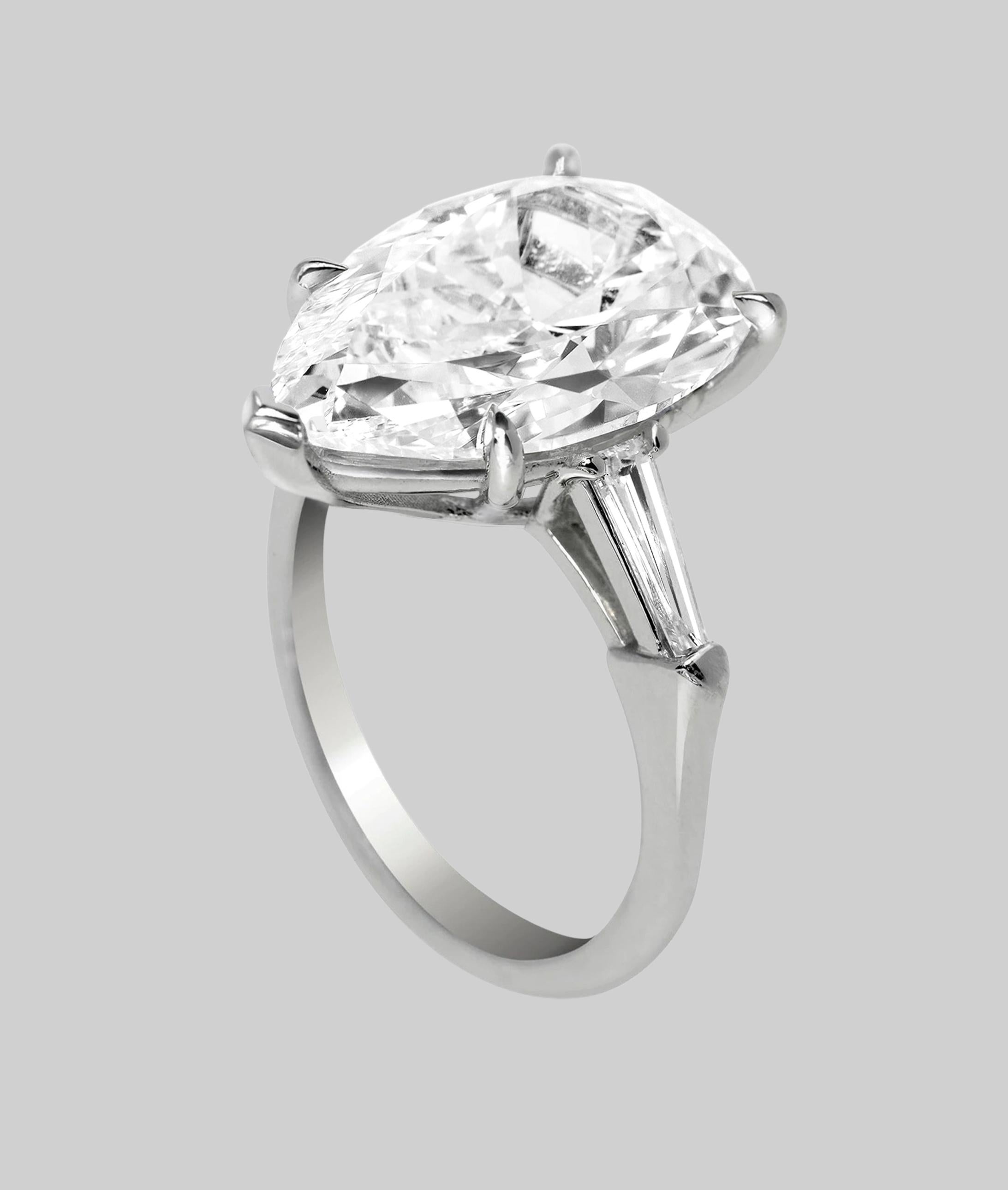 This exceptional engagement ring features a breathtaking 5.03 carat pear shaped diamond, certified by GIA for it's unparalleled quality. 
Set in premium platinum, it is designed with a timeless three stone layout.

The central diamond is