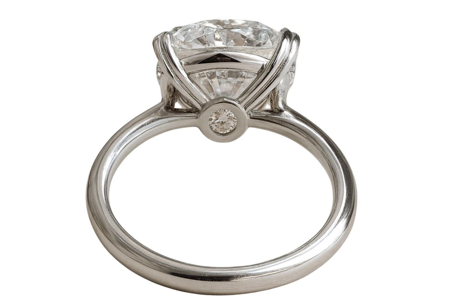 This exquisite engagement ring features a GIA certified 5 carat round cut diamond set in a sleek platinum band, exuding timeless elegance and refined craftsmanship.

With a F color grade, the diamond reaches the highest level of colorlessness,