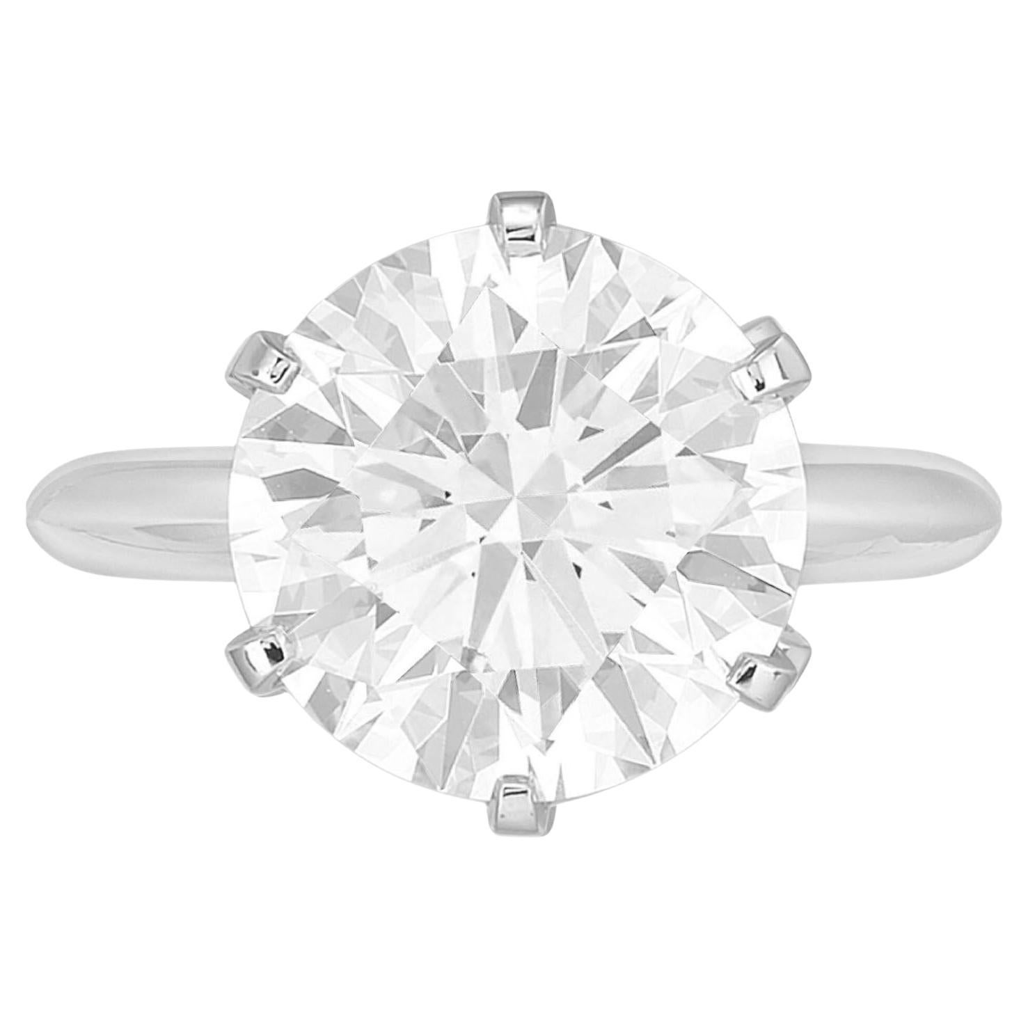 Parez-vous de l'élégance intemporelle de cette bague solitaire en diamant rond de 5,02 carats certifiée par le GIA, un symbole époustouflant de beauté et de sophistication éternelles. La pièce maîtresse de cette bague exquise est un captivant