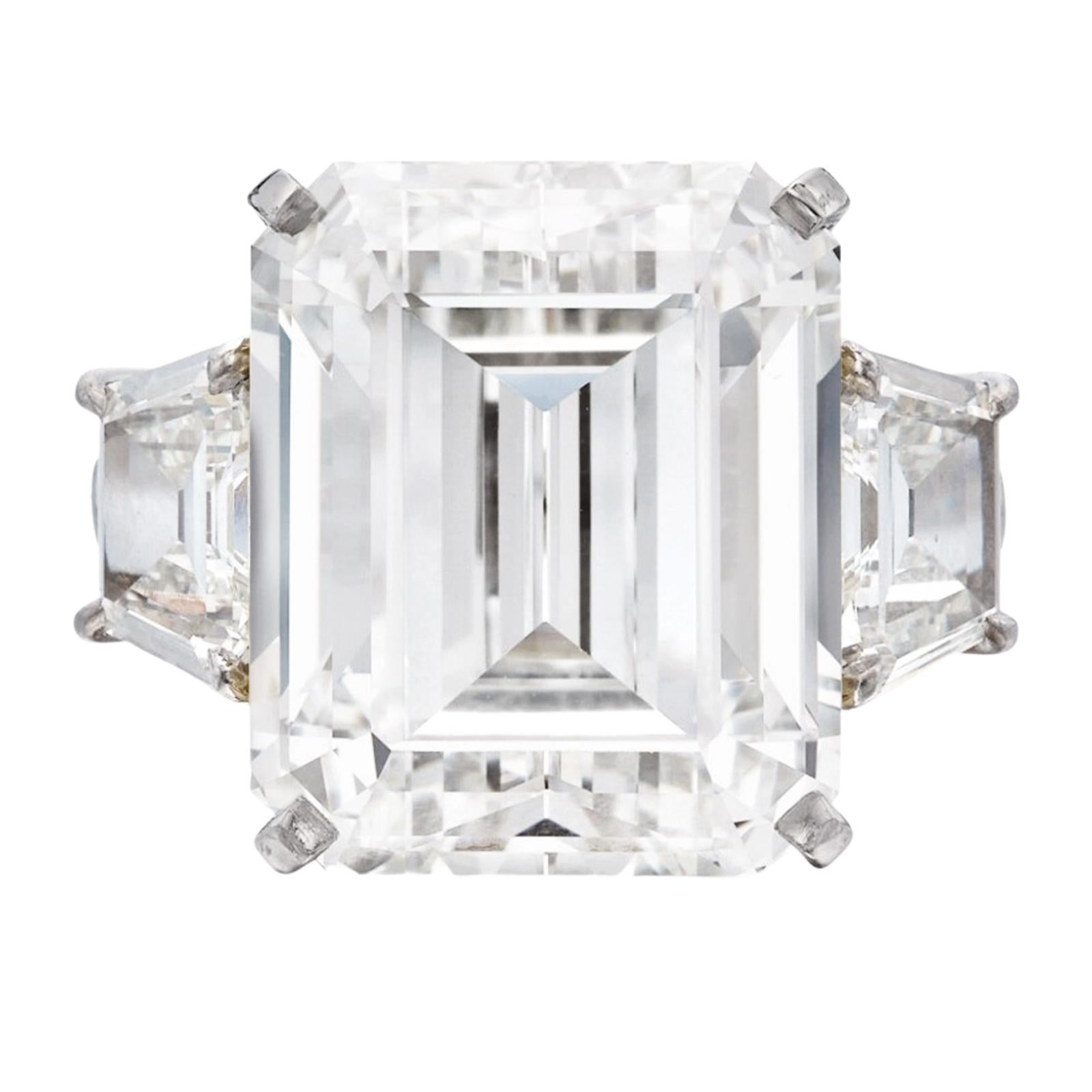 The 5.00 carat E color VS emerald diamond ring in 18K white gold, adorned with trapezoid baguettes, is an exquisite and opulent piece of jewelry. At the center of this ring gleams a captivating emerald-cut diamond weighing an impressive 5.00 carats.