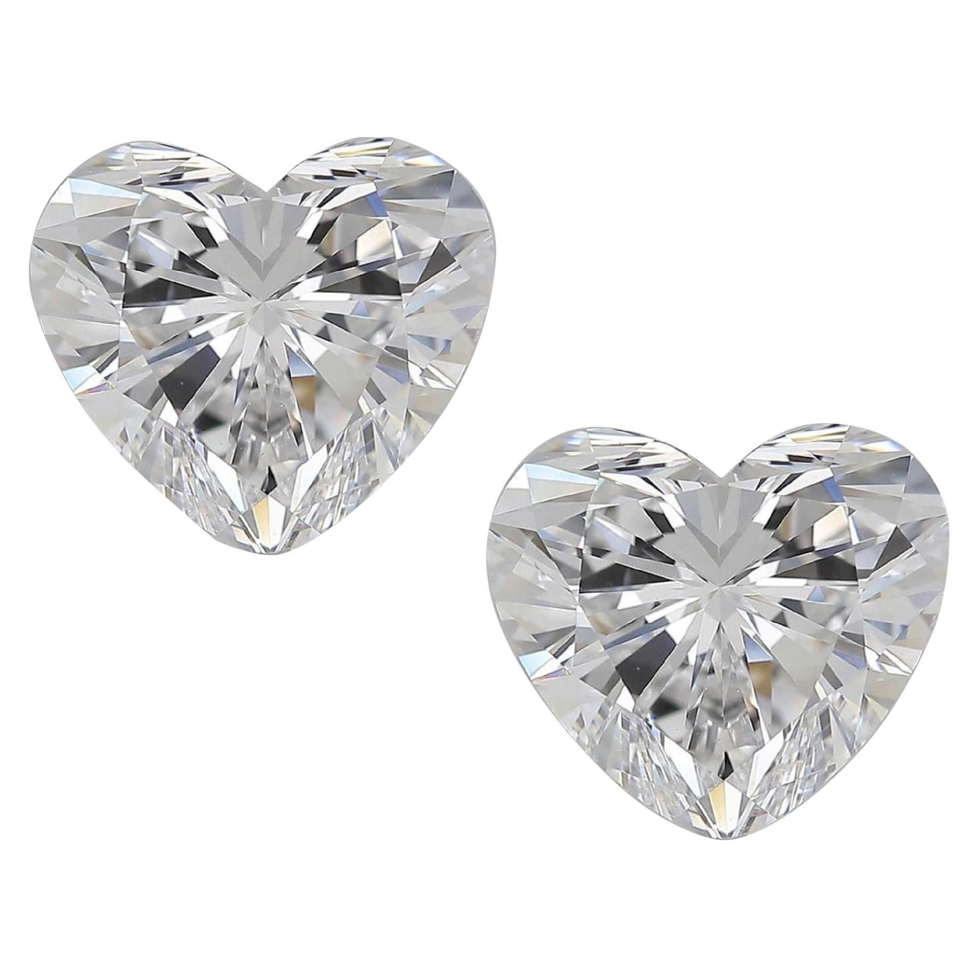 Eleva tu elegancia con este exquisito par de pendientes de diamantes talla corazón. Engarzadas en brillantes tachuelas de platino, estas extraordinarias gemas tienen un encanto cautivador. Los diamantes irradian un brillo que capta cualquier