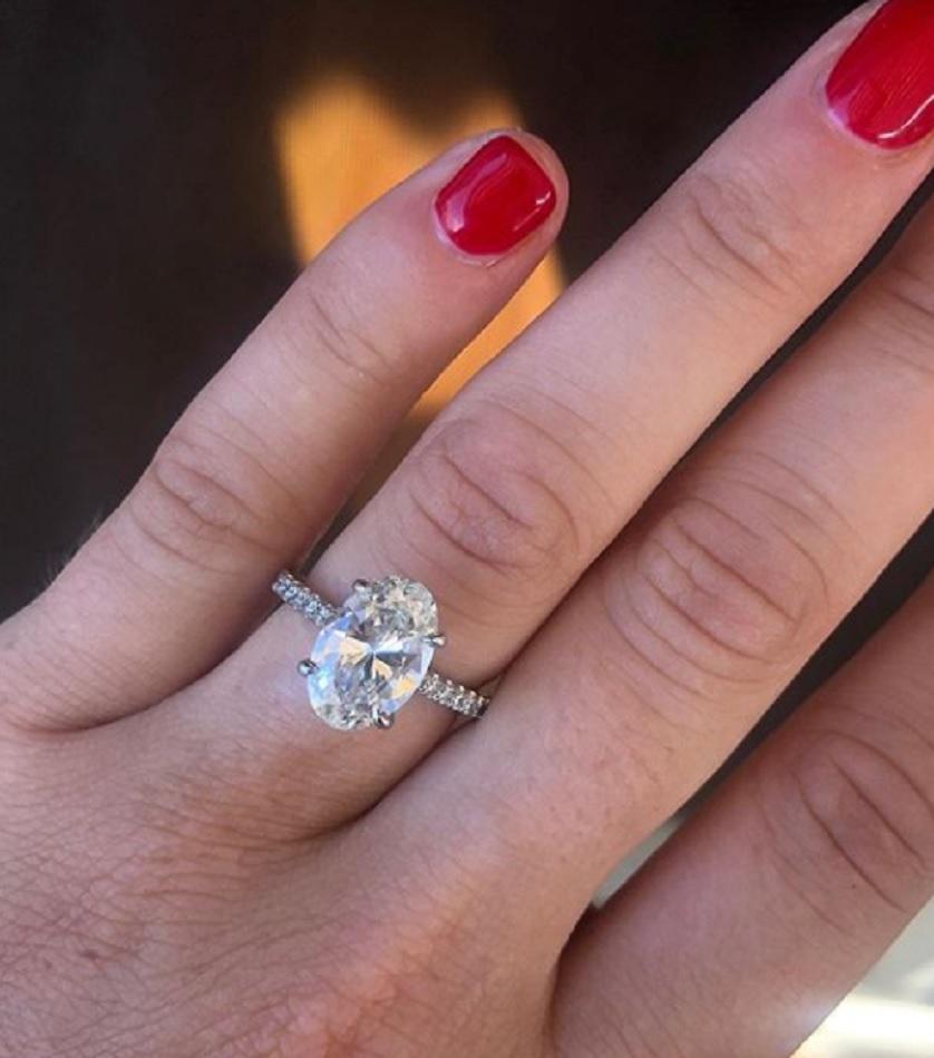This elegant ring features a stunning 5.01 carat oval cut diamond, certified by the GIA for it's superior quality. Surrounding the center diamond is a delicate pavé of smaller diamonds, adding extra sparkle and sophistication to the design.

This