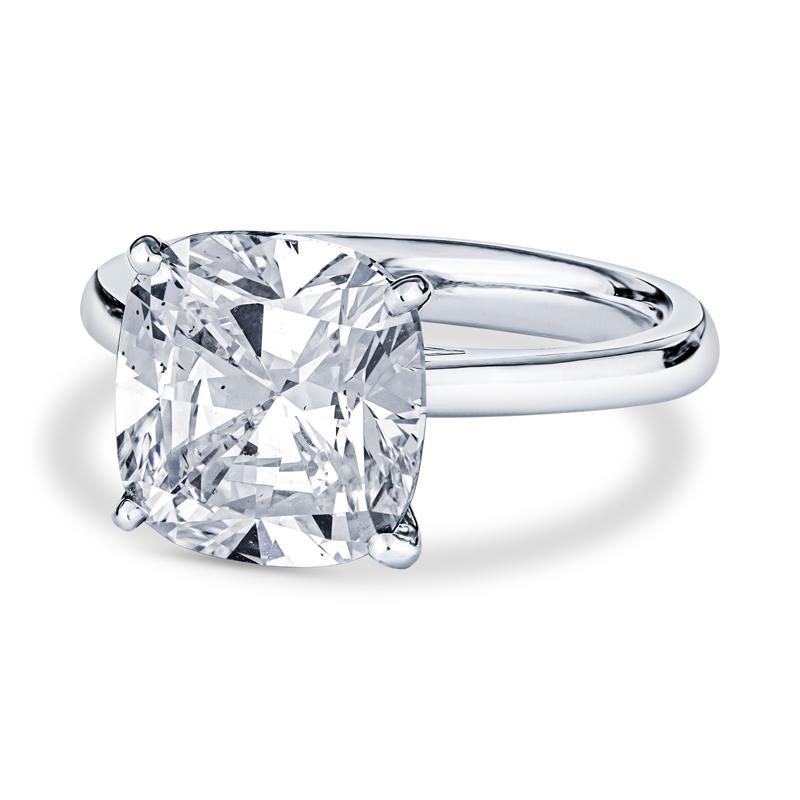This beautiful solitaire engagement ring features a 5.01 GIA certified cushion cut diamond, G SI1, set in platinum. It is a phenomenal ring that shines from every angle. It is currently a size 6 but can be resized upon request. 
Measurements: 10.50