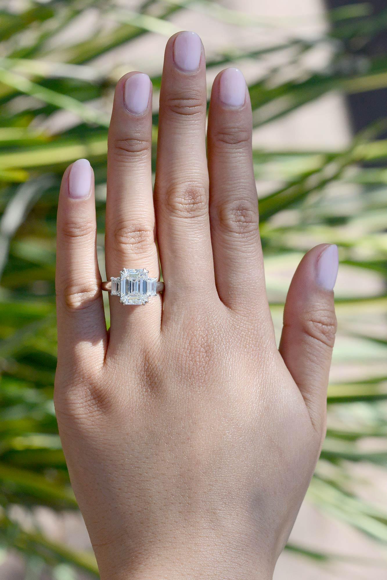 This luxurious diamond ring is a true masterpiece of high jewelry, featuring a stunning 5.01 carat emerald cut diamond that has been certified by the Gemological Institute of America (GIA) for its exceptional quality and brilliance. Graded as K
