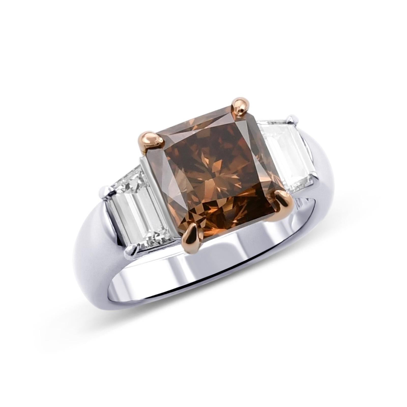 Handmade platinum & 18k rose gold ring with 2 trapezoids on the side F & color VS clarity TW. 0.65ct, center diamond is radiant cut of Natural Fancy Dark Orange Brown color & VS2 clarity 
GIA#2205876326

Viewings available in our NYC wholesale