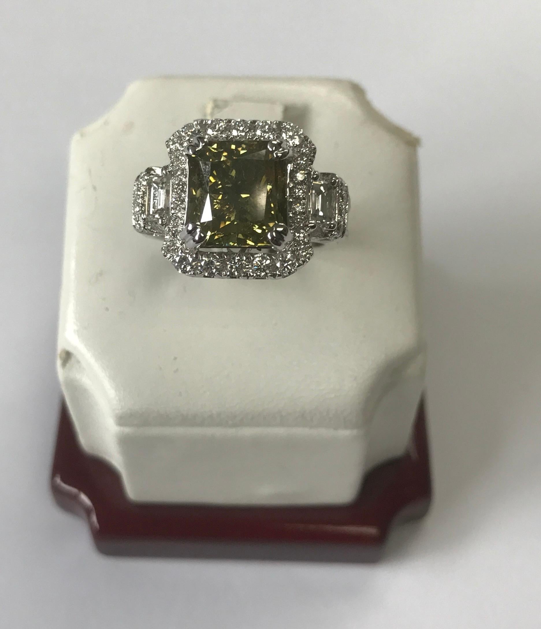 Natural Fancy Dark Brown-Greenish Yellow Cushion Diamond Weighing 5.01 carats by GIA. Beautifully paved with baguette diamonds in the halo setting. Its transparency and luster are excellent. set on 18K white gold, this ring is the ultimate gift for