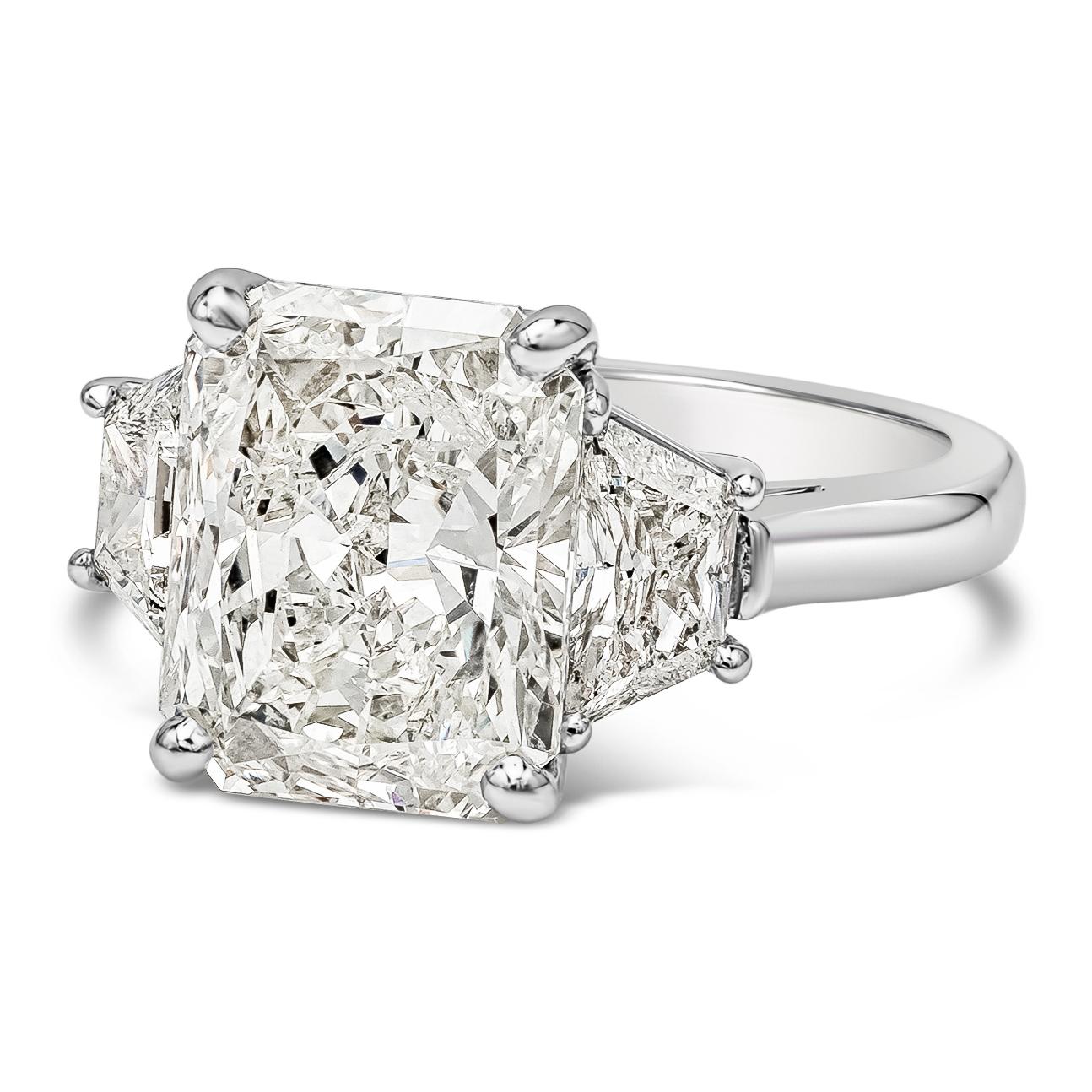 Elegant and well crafted three stone engagement ring features a 5.01 carat radiant  cut diamond certified by GIA as J color, SI2 clarity, set in a platinum four prong basket setting. Flanked by brilliant trillion cut diamonds on each side weighing