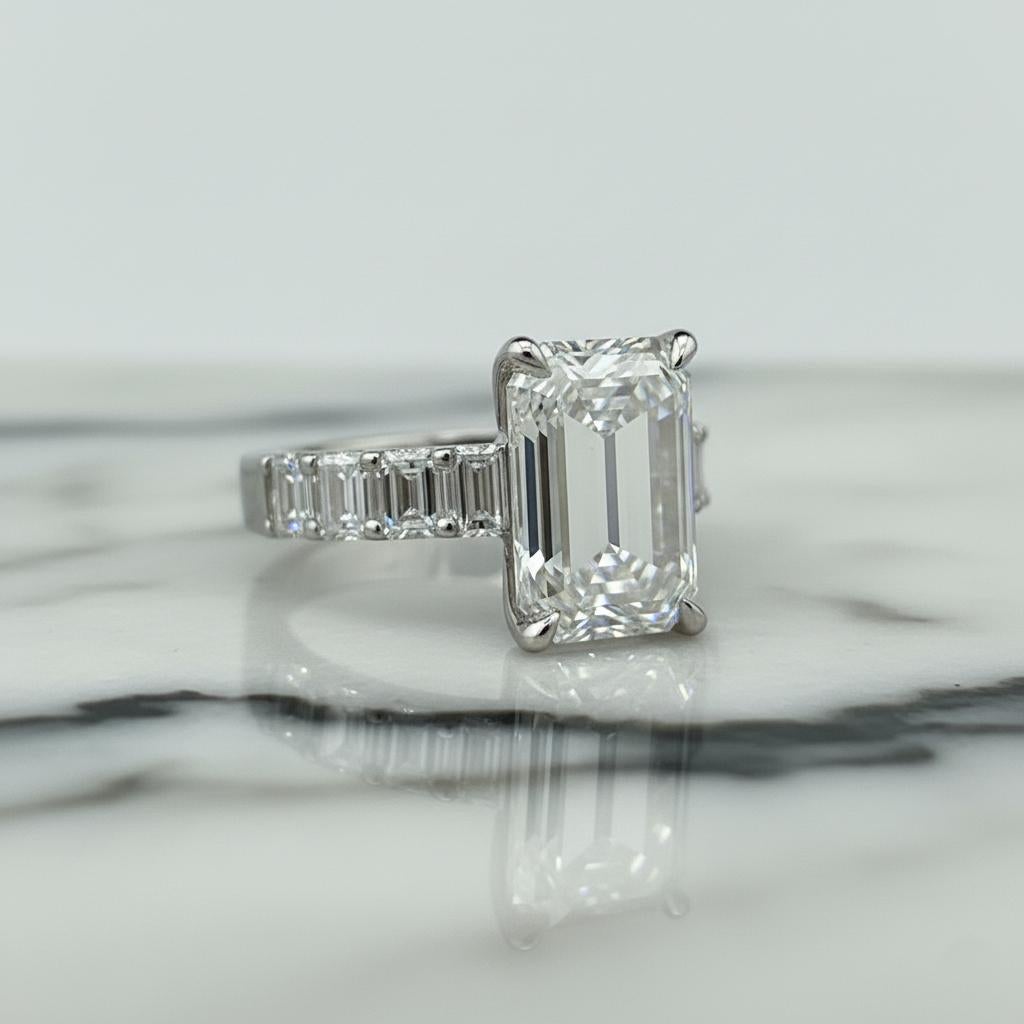 Cette bague à l'élégance intemporelle met en valeur un magnifique diamant taille émeraude de 5 carats certifié GIA, de couleur I et de pureté VS2.
Le diamant central présente une brillance et une clarté exceptionnelles.

Méticuleusement réalisé à la