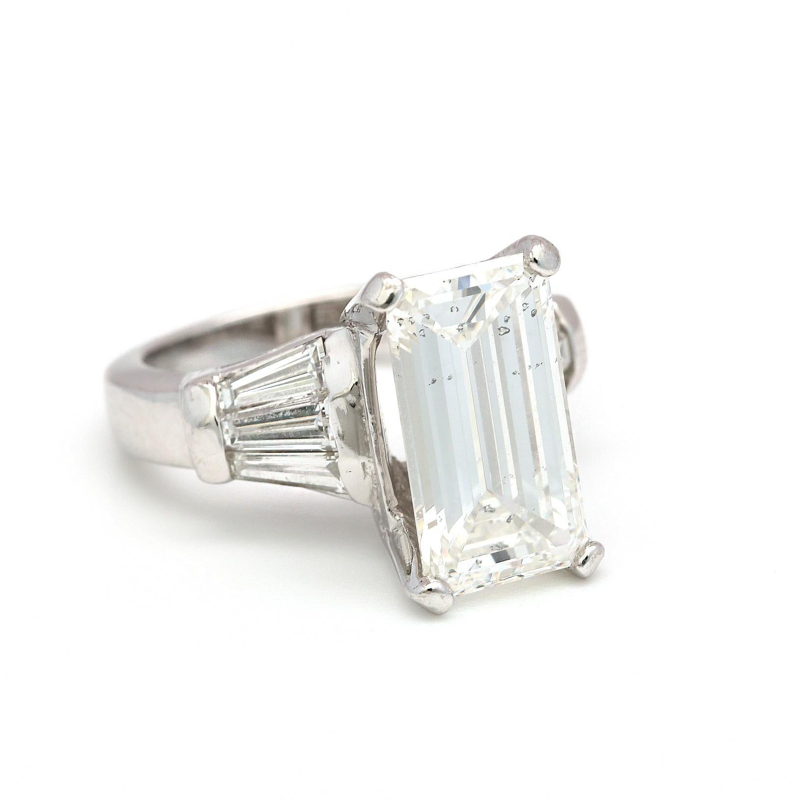 A beautiful Emerald Cut Diamond ring. 
Center Emerald cut diamond is GIA Report at a 5.02 carats H SI2ct (GIA Report # 5161725200). 
Side diamonds are approximately 1 carat with same quality but not certified, giving this ring a total carat weight