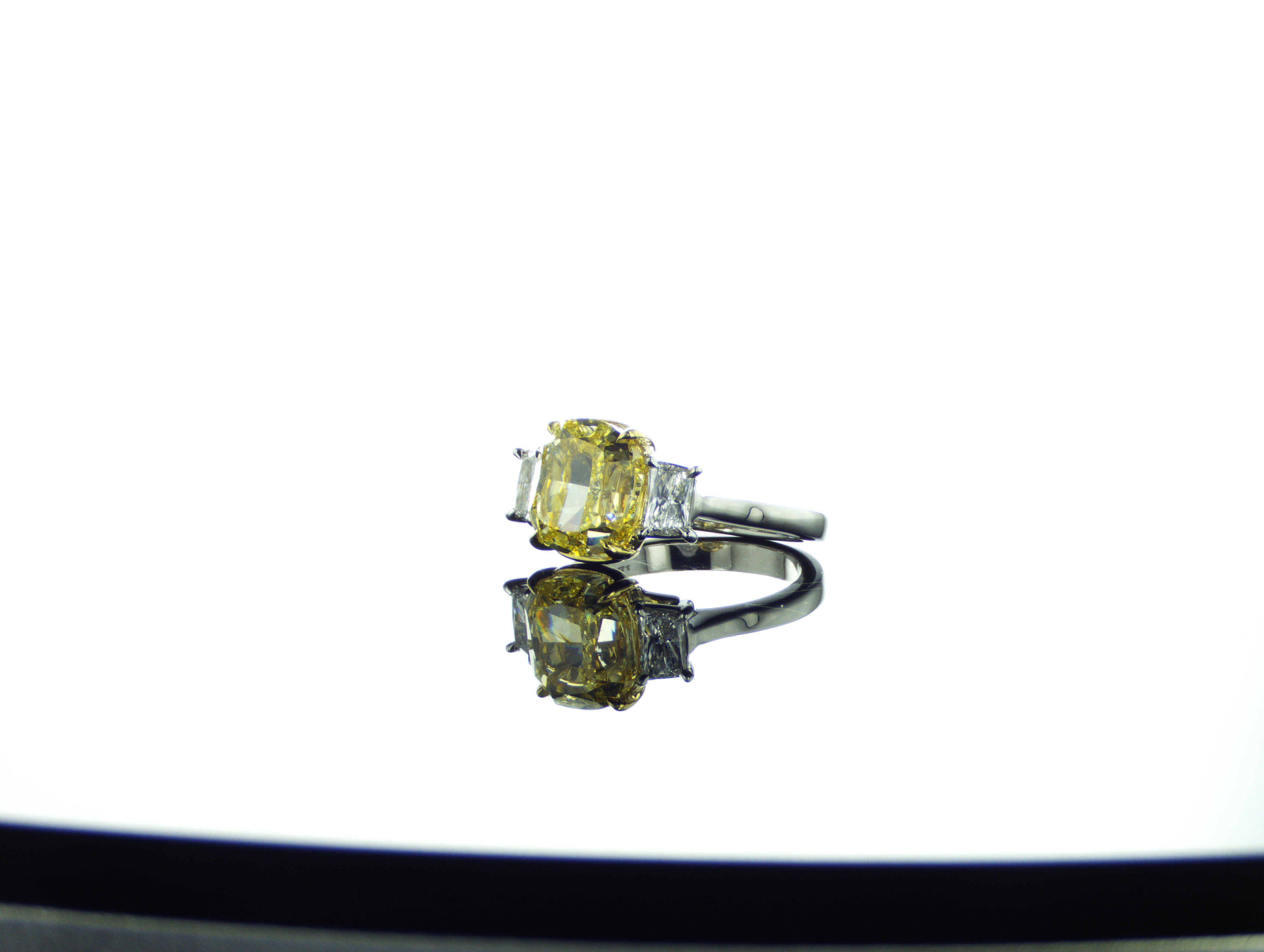 Stunning modern absolutely killer GIA certified fancy intense yellow diamond 3-stones Platinum 950 Ring (Platinum casting has been made in the USA - New York), all diamonds has been cut in our workshop in the UAE (Dubai). 
5.03 carat Cushion Fancy