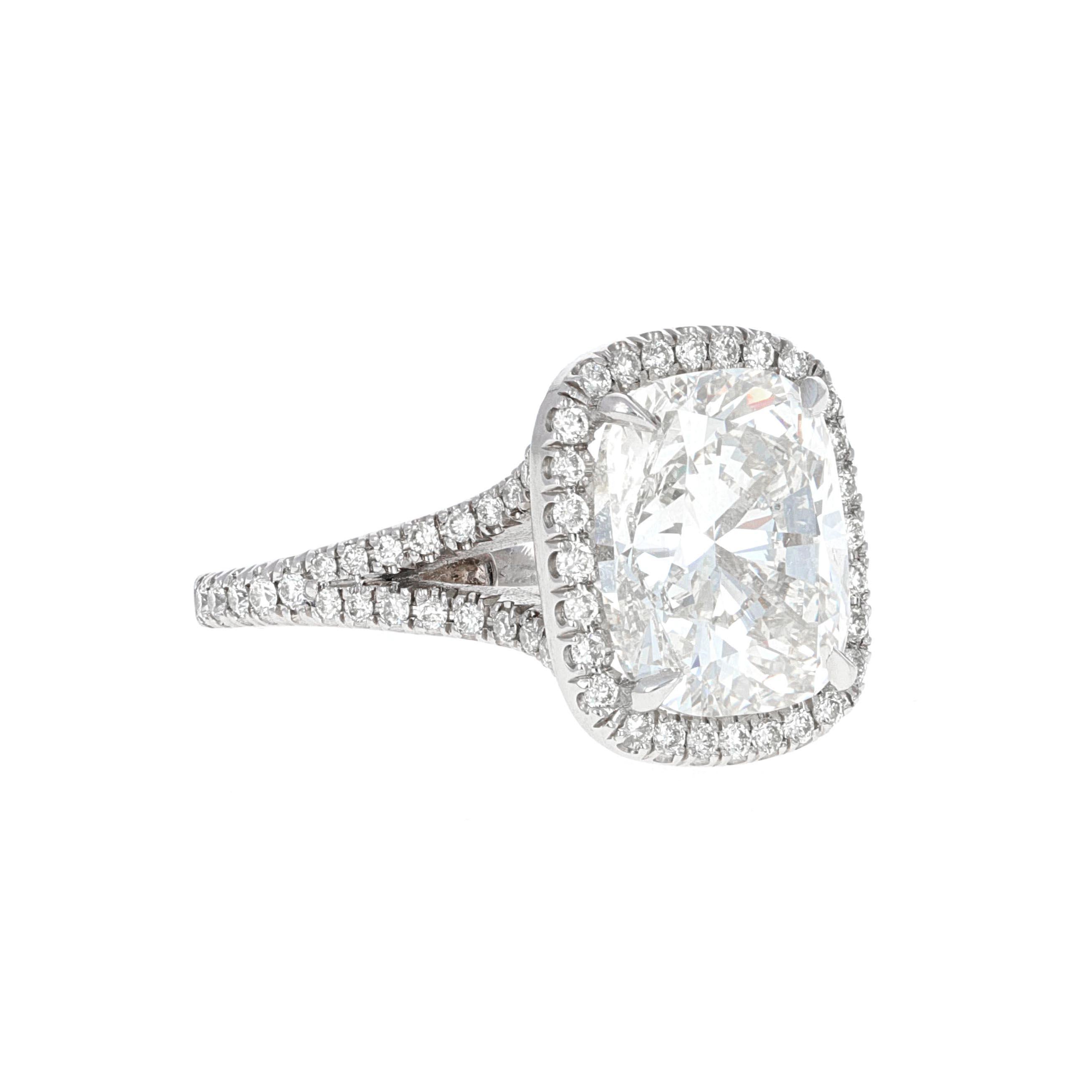 Handmade, M. Kantor and Associates, diamond enagaement ring. This ring is made in platinum with a split shank pave diamond halo mounting. The center stone is a elongated cushion modified brilliant cut weighing 5.04 carats. The stone has been