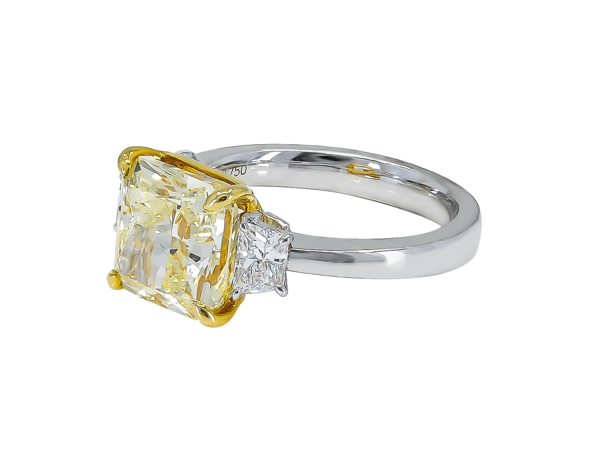 This engagement ring is a breathtaking piece of jewelry that is sure to capture the heart of anyone who lays eyes on it. At the center of the ring is a stunning 5.05-carat fancy intense yellow diamond, cut in a radiant shape that adds to its
