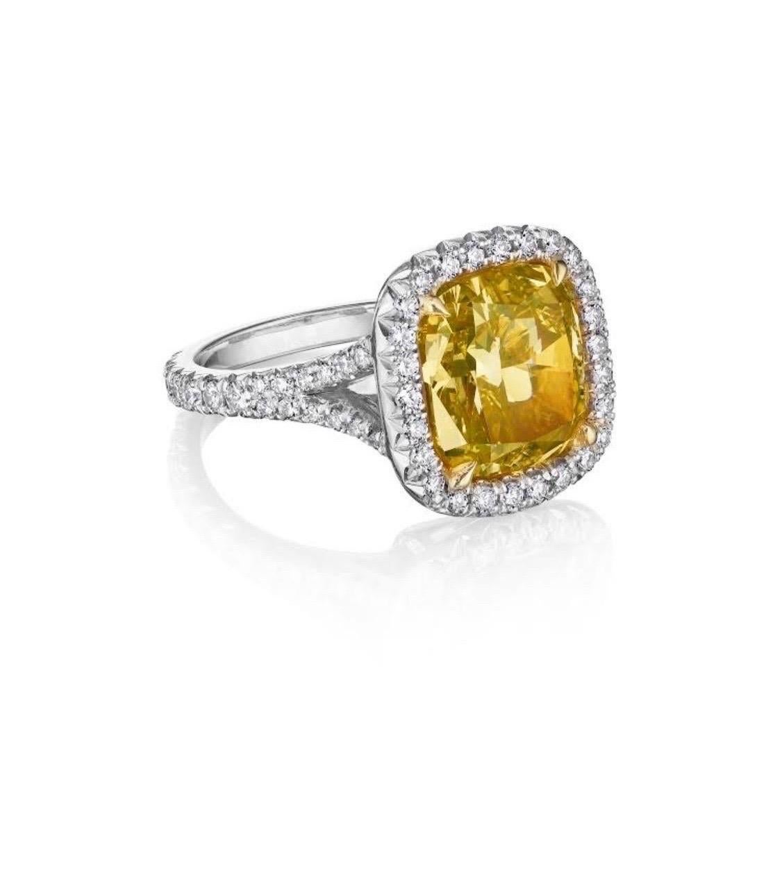This incredible engagement ring features a GIA graded 5.05 carat fancy vivid yellow cushion cut diamond with a VS2 clarity.
This beautiful diamond has incredible saturation of color and ilivley scintillation.
masterfully Set in a halo of white round