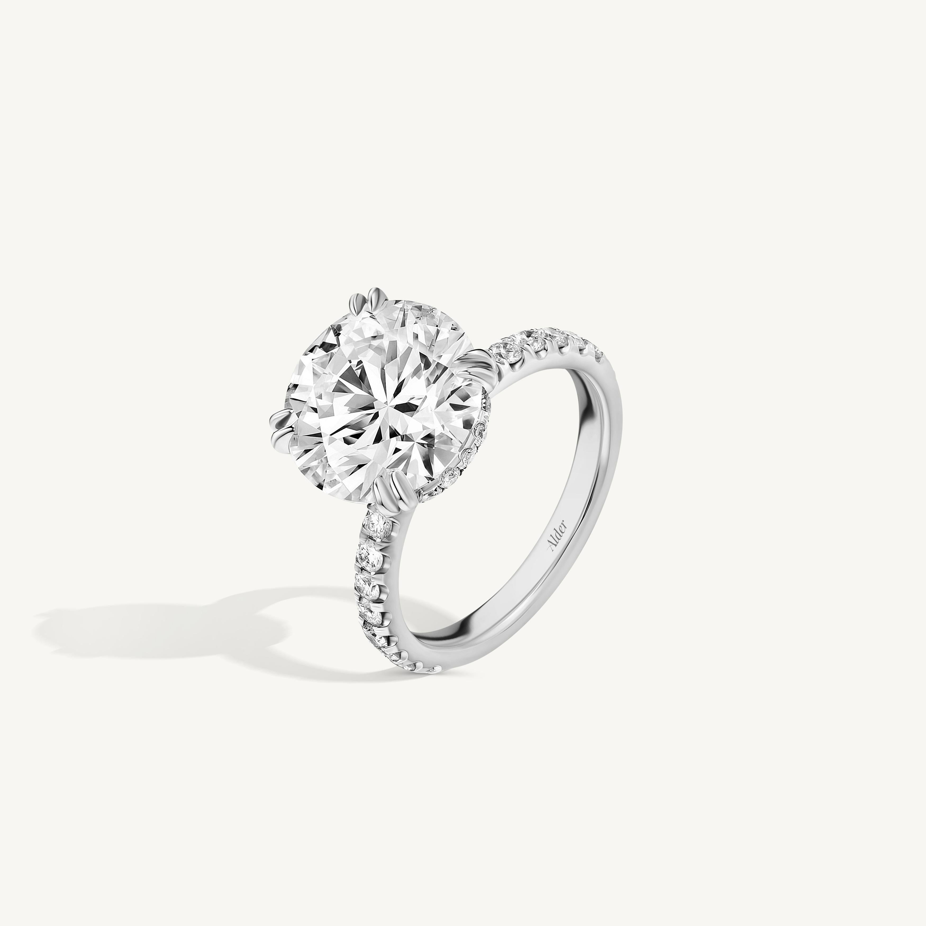 A striking and sophisticated statement piece, this exquisite ring features a dazzling 5.05-carat round brilliant cut diamond, graded H color and VS2 clarity, and certified by GIA. The center stone is securely set in a platinum setting, offering a