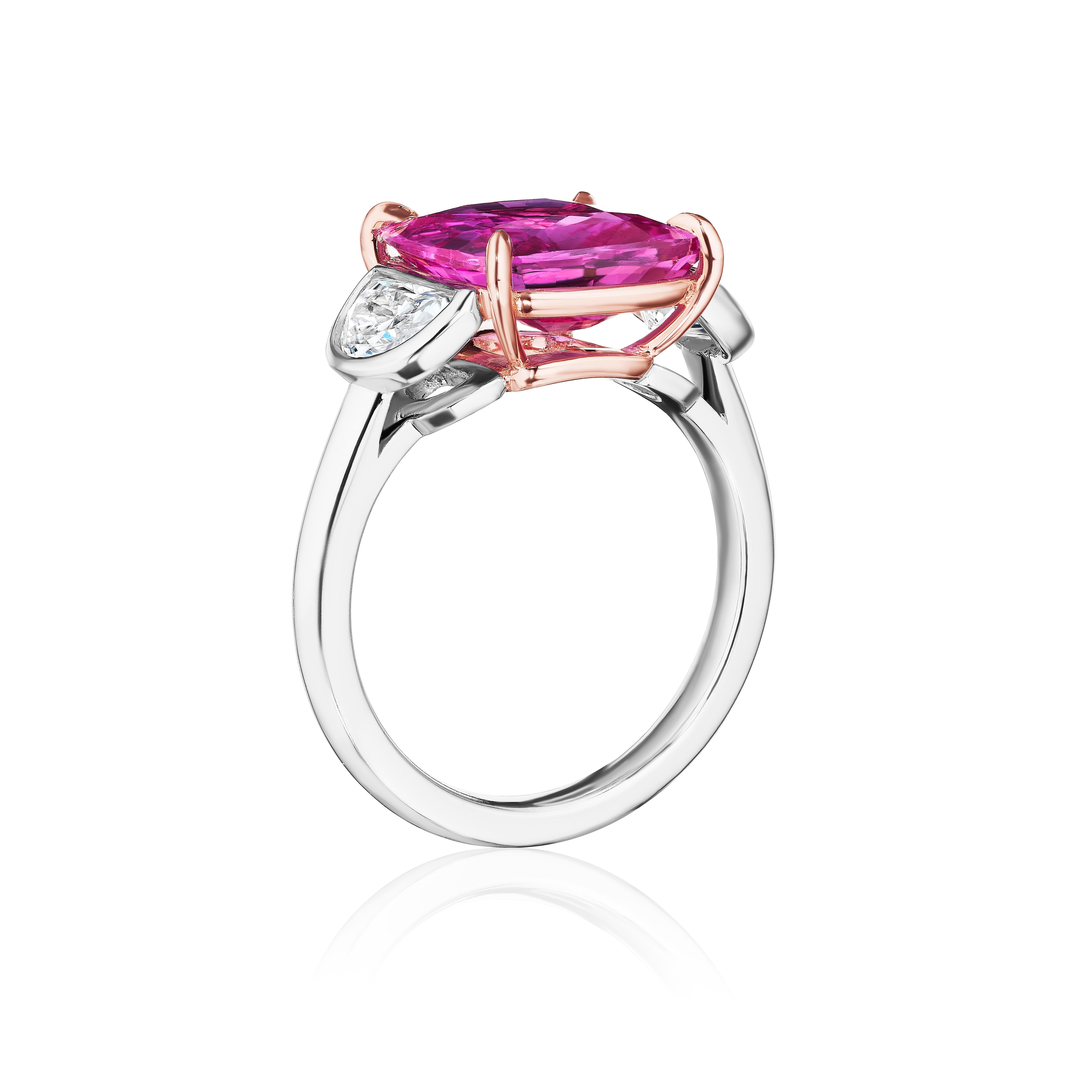 Pink Sapphire and Diamond Three Stone Ring. 

Centered upon a Cushion Cut Pink Sapphire weighing 5.07 Carats with GIA certificate stating the stone is heated and from the mines of Madagascar. 
Flanked by Half Moon Diamonds weighing 0.84 Carats of F