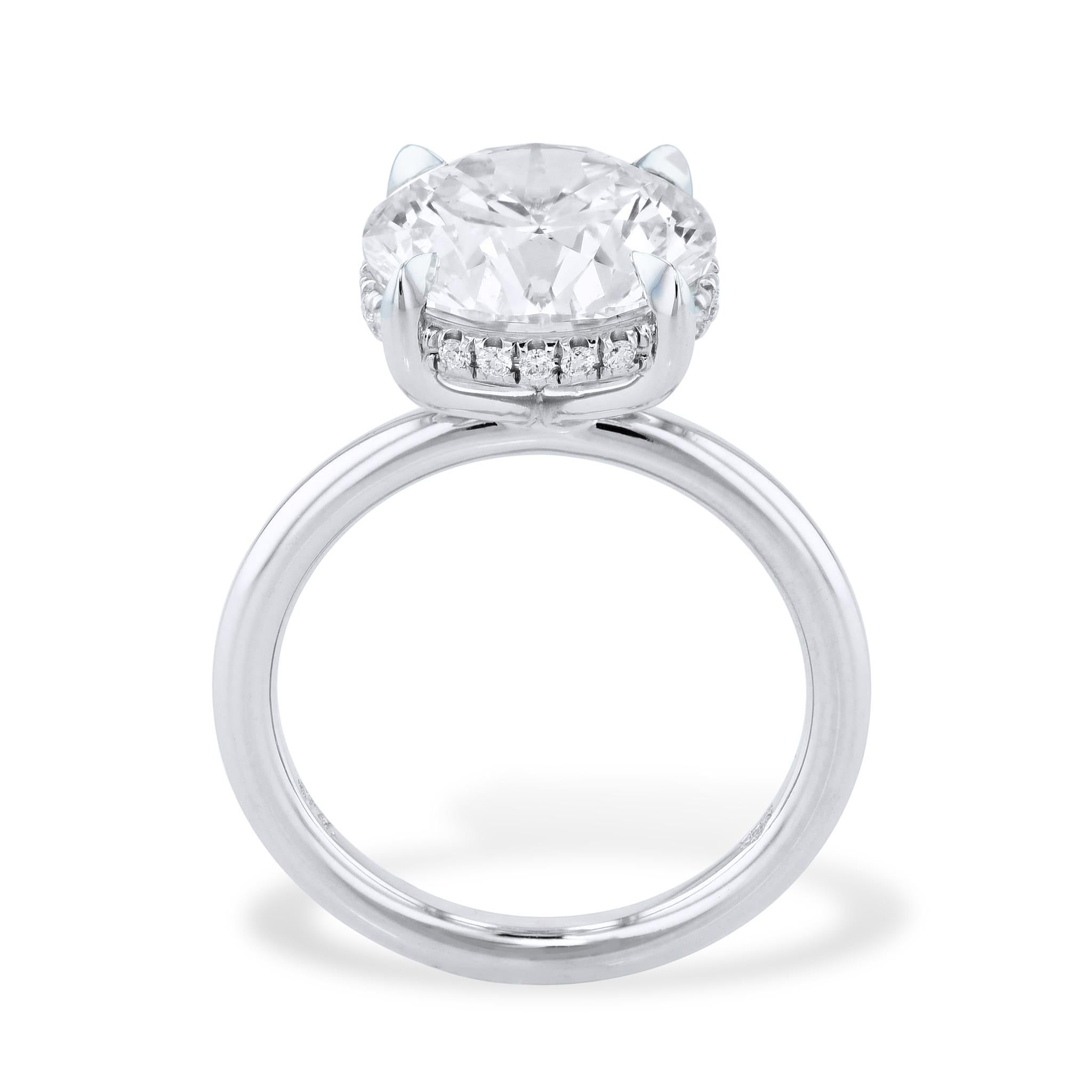 This captivating round diamond platinum engagement ring features an exquisite 5.07 carat center diamond and is enhanced with diamond pave that gleams underneath the basket for a truly remarkable look. 

The center stone is GIA certified. The number