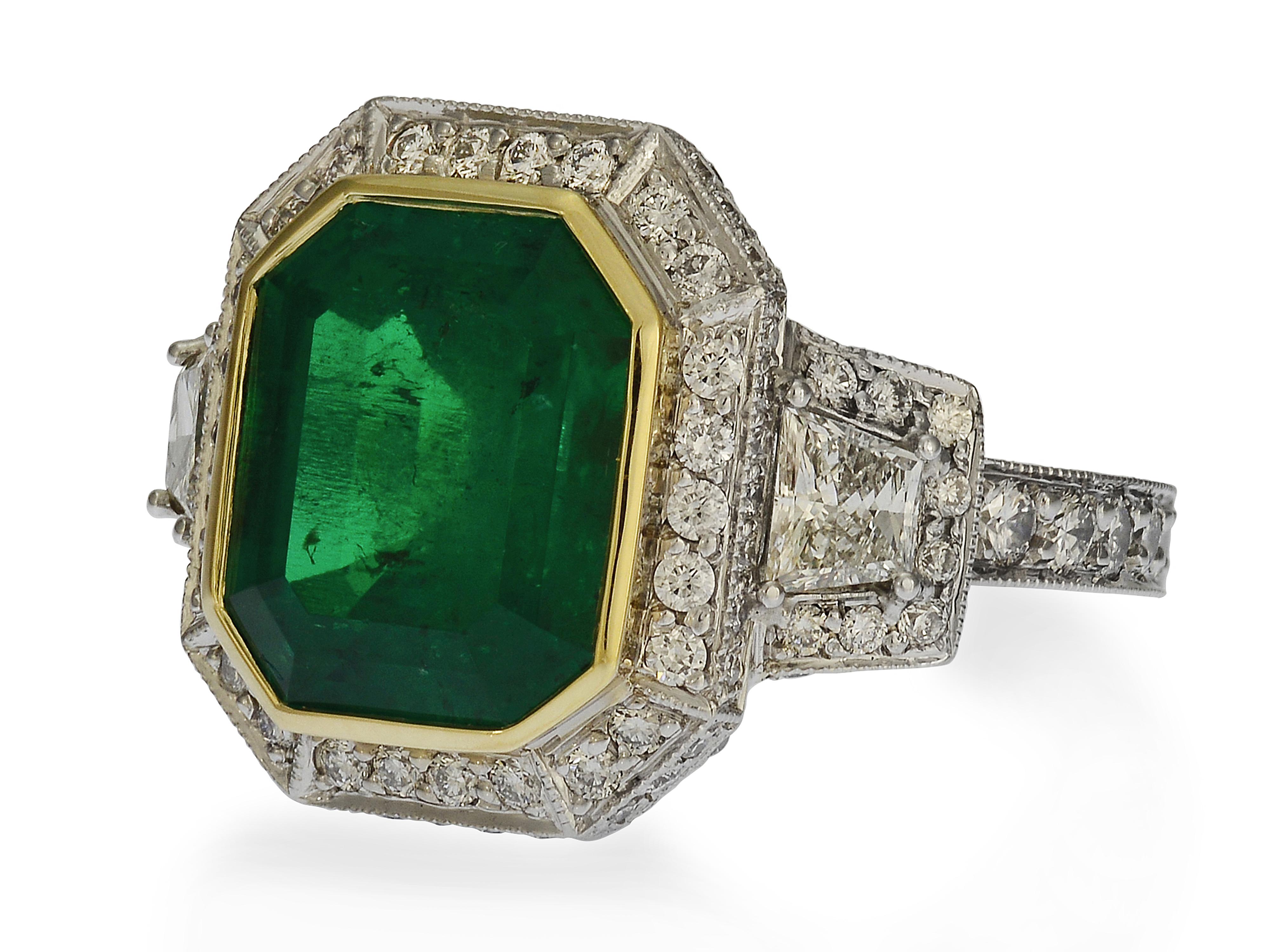 This one-of-a-kind Colombian emerald cocktail ring is custom made in 18 karat white gold with an 18 karat yellow gold bezel. The centerpiece is an emerald cut Colombian emerald, graded by GIA as natural & transparent, with minimal (F1) treatment.