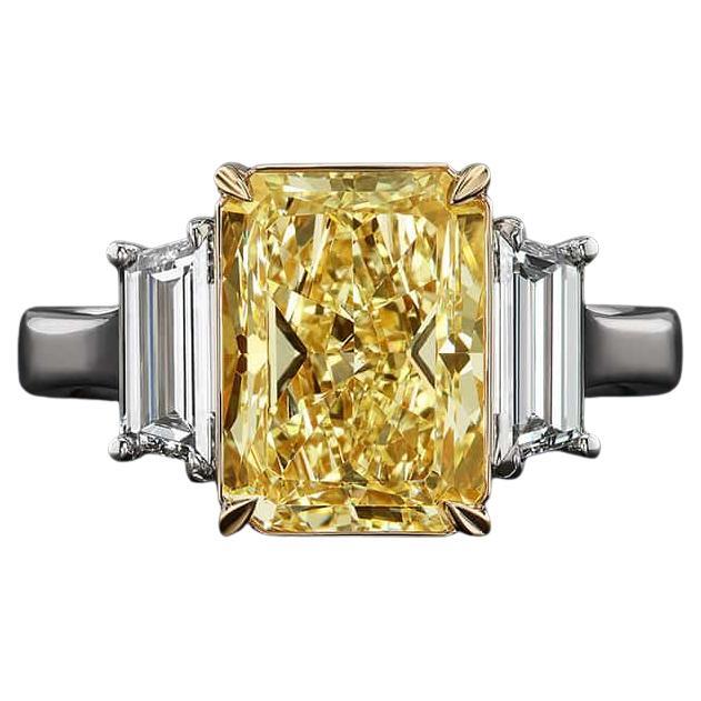 This exquisite ring features a GIA certified 5.67 carat fancy yellow radiant cut diamond, elegantly set in a luxurious design that combines 18K white gold with 18K yellow gold accents. The vibrant yellow diamond is cradled in a yellow gold setting,