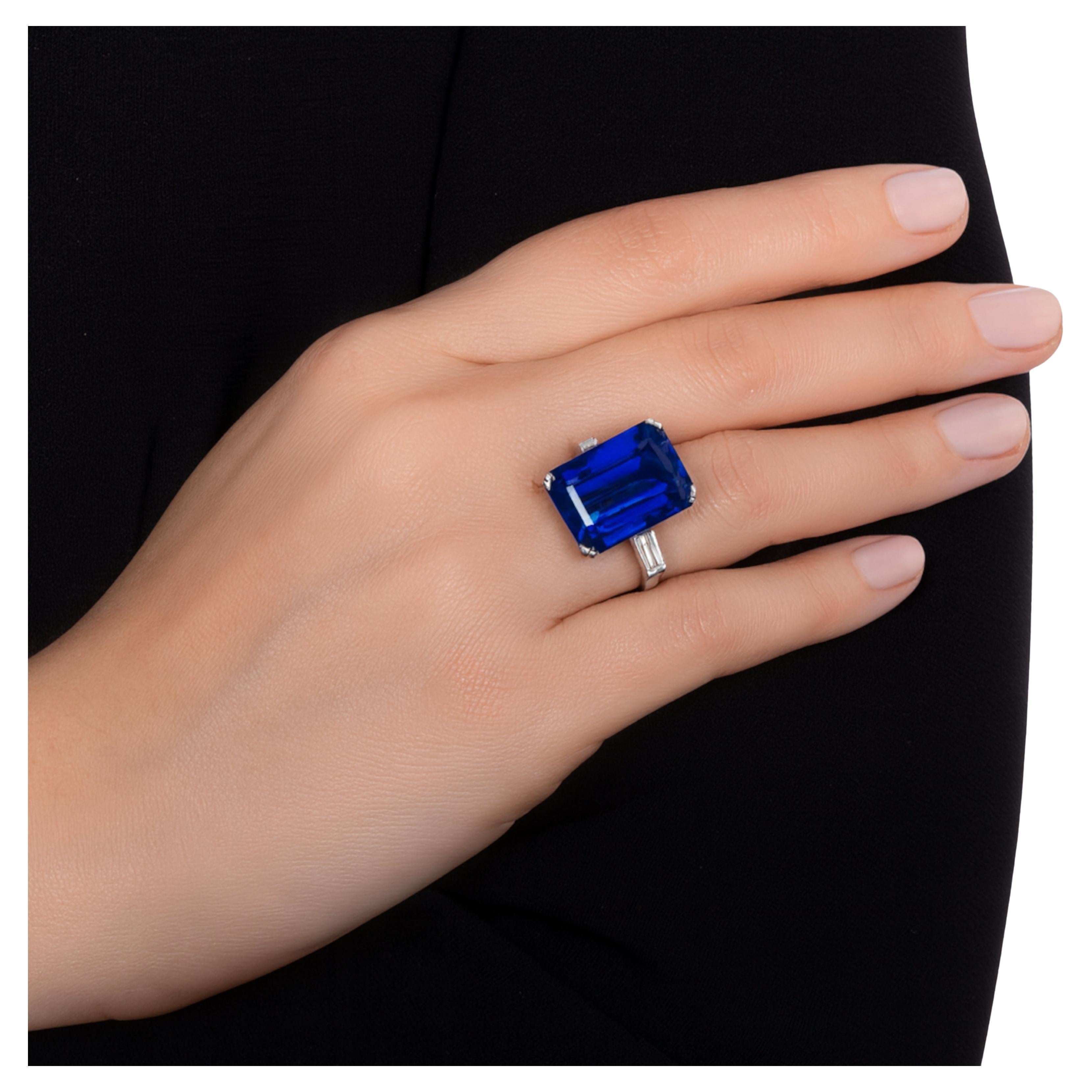 ste exquisito anillo exhibe un impresionante zafiro azul natural sin tratar, certificado por el GIA, en una elegante talla esmeralda. El zafiro muestra una tonalidad azul vívida y aterciopelada y es completamente limpio a la vista, reflejando un