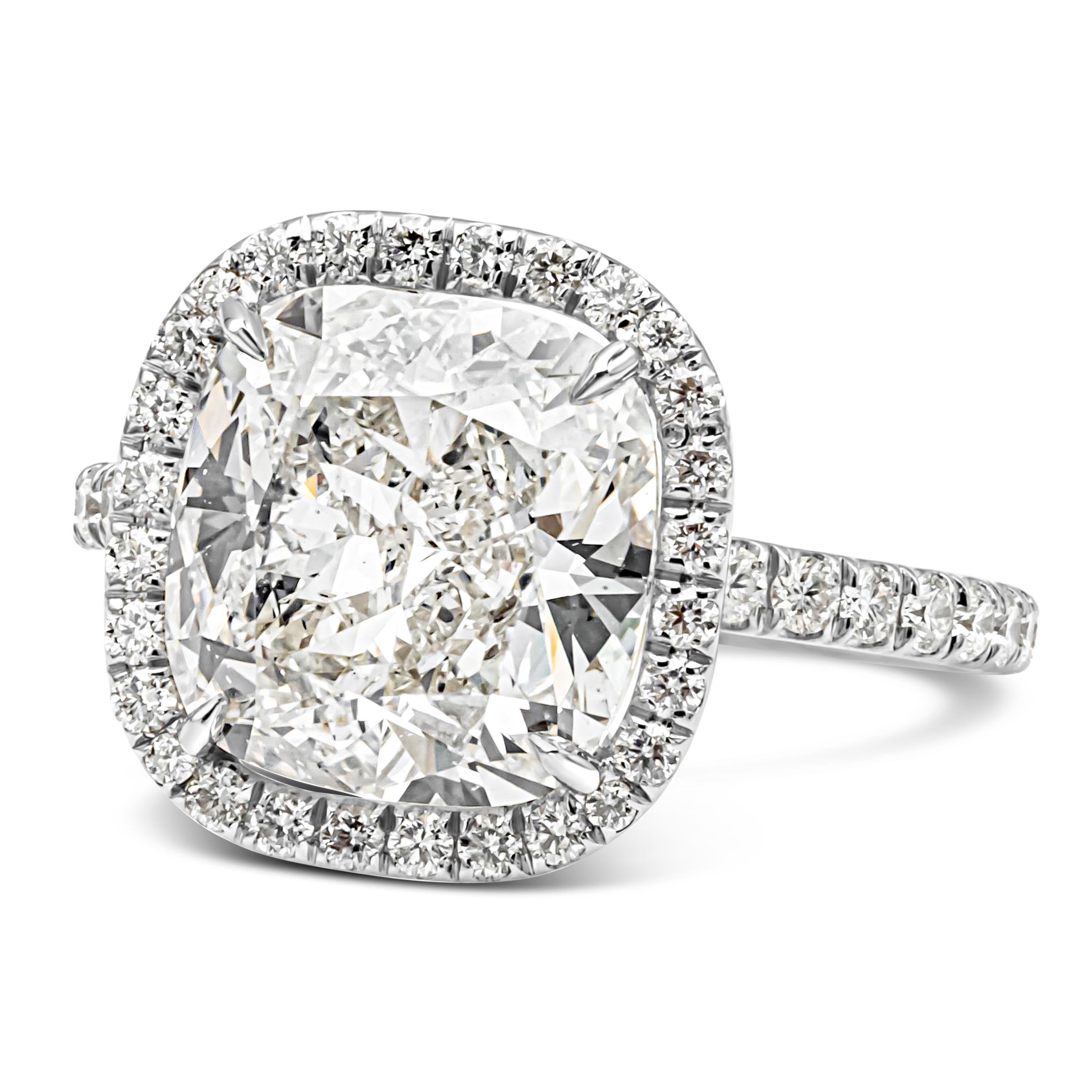 An elegant engagement ring, featuring a 5.19 carats cushion cut diamond certified by GIA as J color and SI1 clarity, set on a four prong setting. Surrounded by a halo of round brilliant cut diamonds an accented by a diamond encrusted shank on a