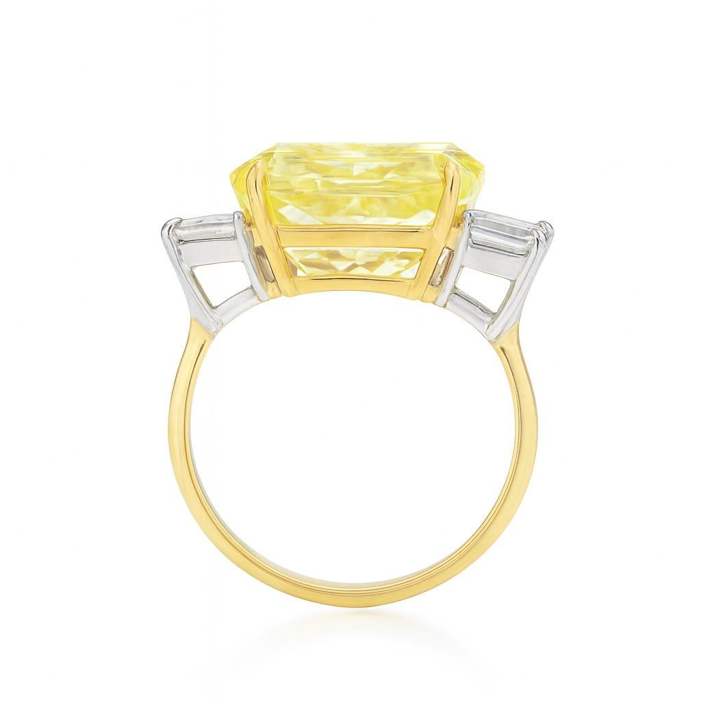 Dieses auffällige Schmuckstück aus 18 Karat Gelbgold und Platin ist auf beiden Seiten mit eleganten Diamanten im Smaragdschliff besetzt, die den lebhaften Gelbton des Mittelsteins perfekt zur Geltung bringen.

Der GIA-zertifizierte 5,24-karätige