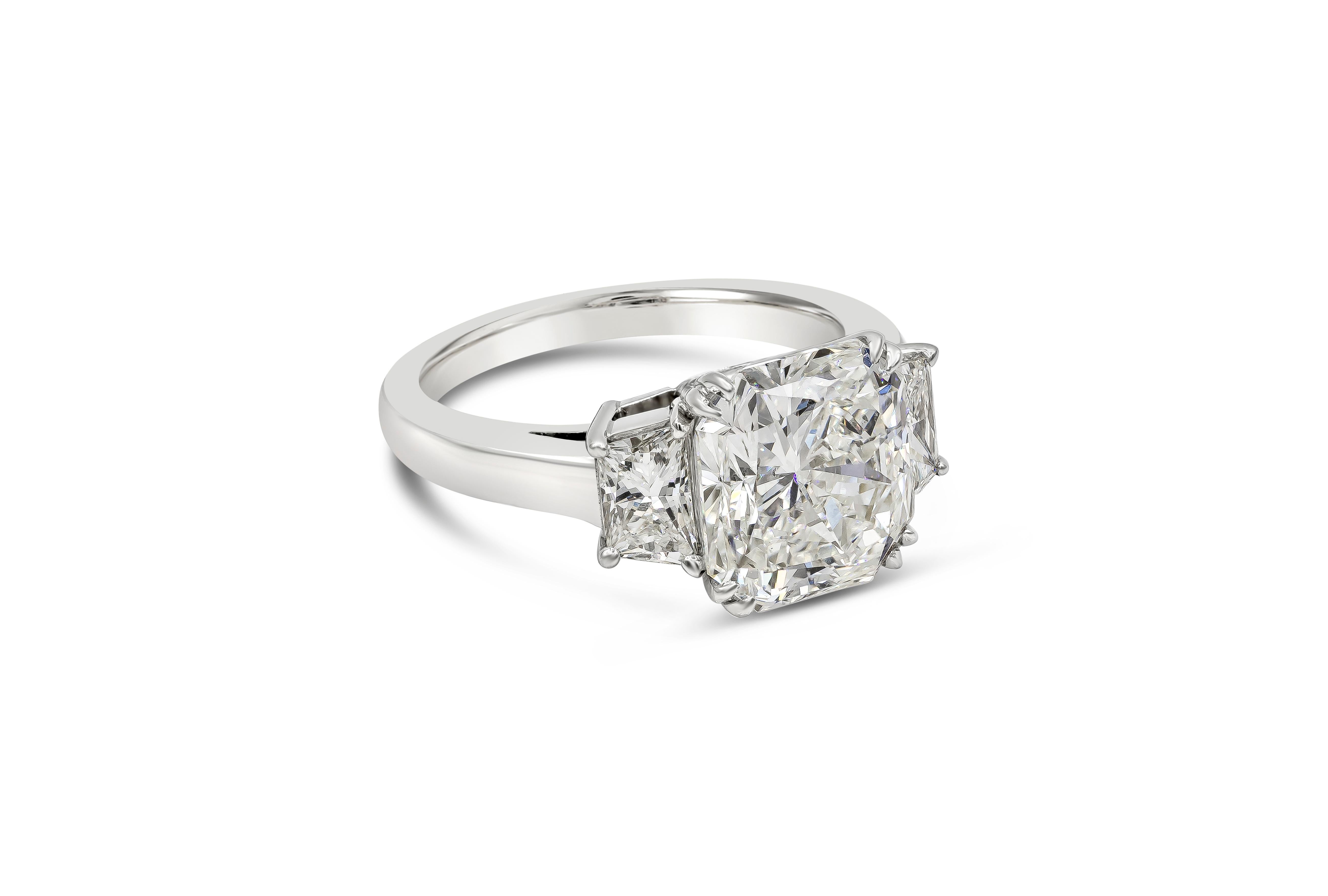 A timeless classic showcasing a GIA Certified 5.24 carat total radiant cut I Color and SI1 in Clarity. Flanking the center stone are two perfectly-matched brilliant trapezoid diamonds weighing 1.02 carats total. Made with Platinum. Size 6.25