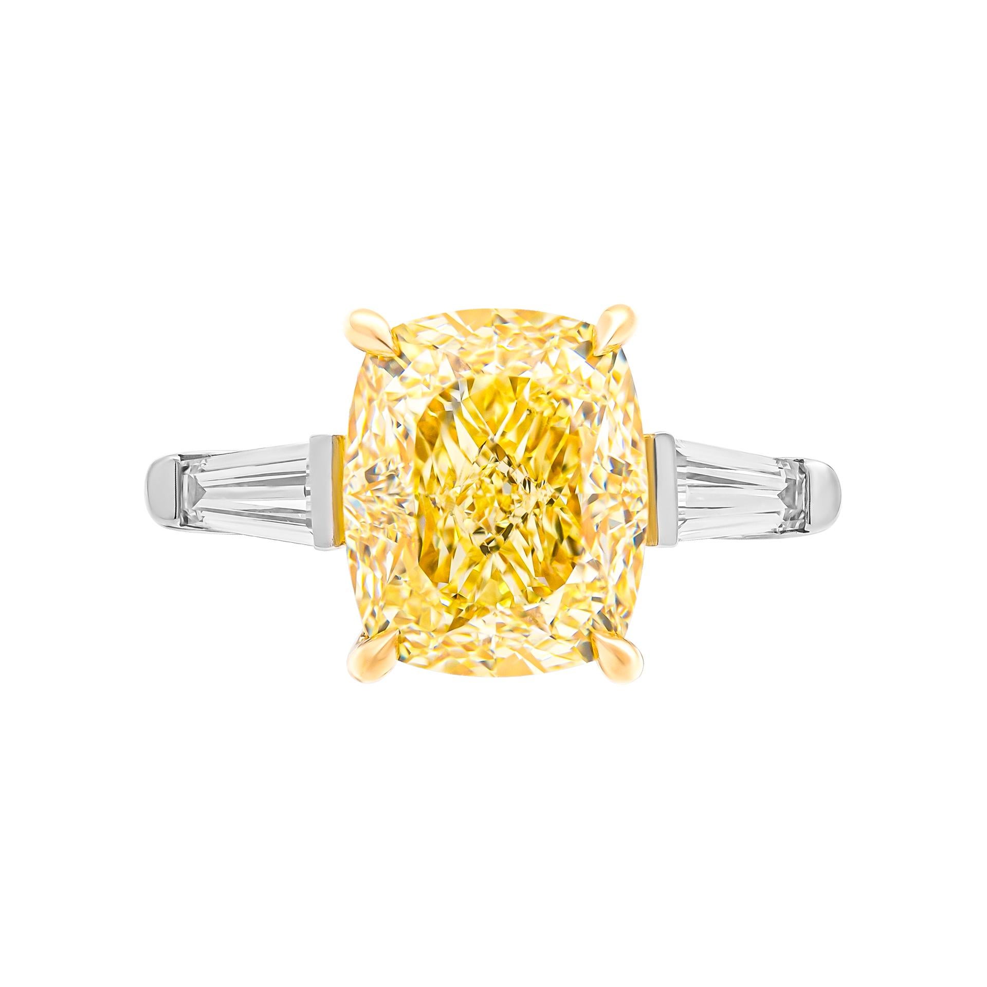 3 stone ring in Platinum & 18K Yellow Gold
Center stone: 5.24ct Fancy Light Yellow VS2 Cushion Shape Diamond GIA#7432512211 
Side stones: 0.56ct F VS tapered baguettes
Total Carat Weight yellow stones: 0.06ct 
Total Carat Weight white stones: