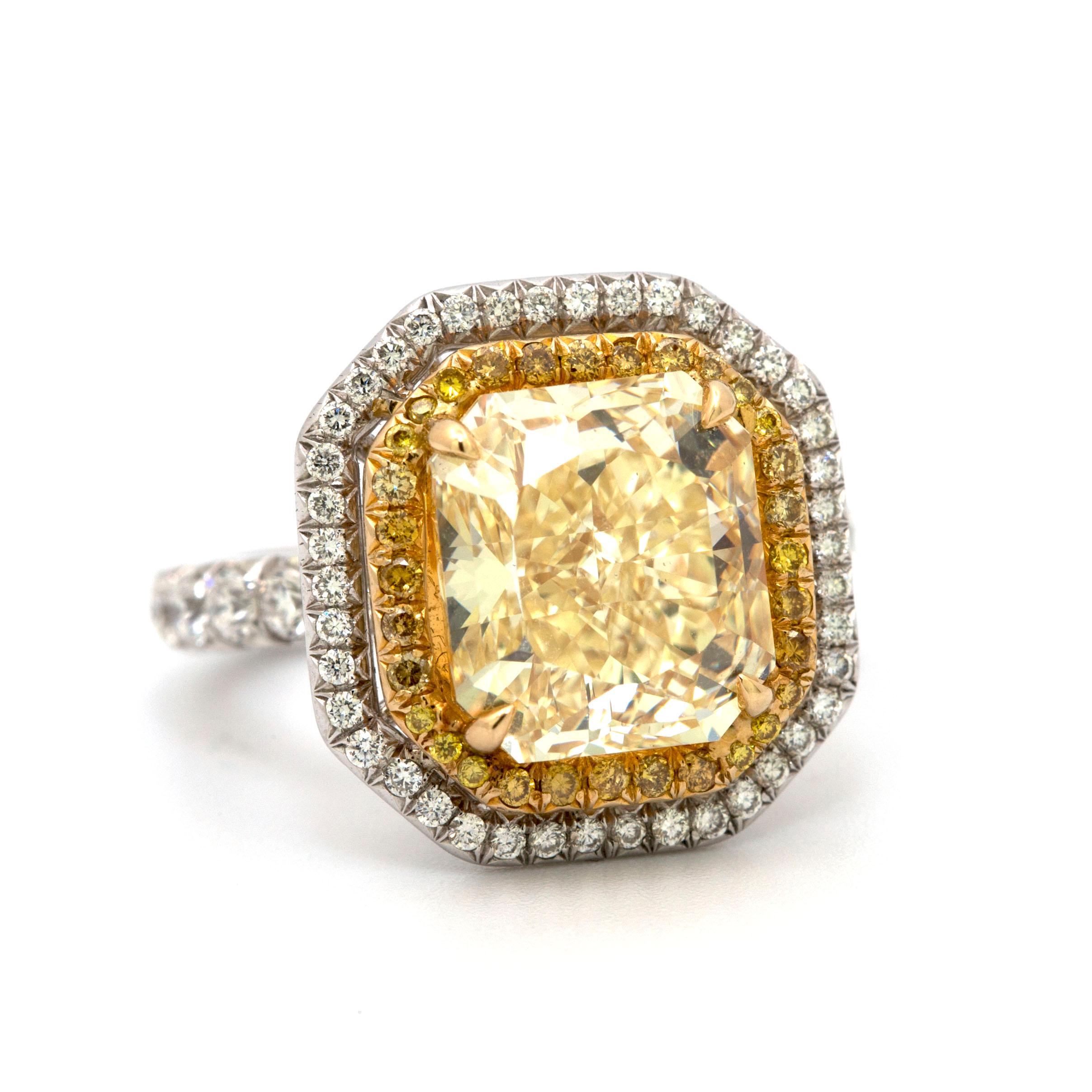 This beautiful ring showcases a canter diamond of 5.26 carats accompanied by a GIA diamond grading report #1172126790, indicating a grading of Fancy Yellow color and VS2 clarity,

Set in platinum & 18 karat gold ring with one row of yellow round