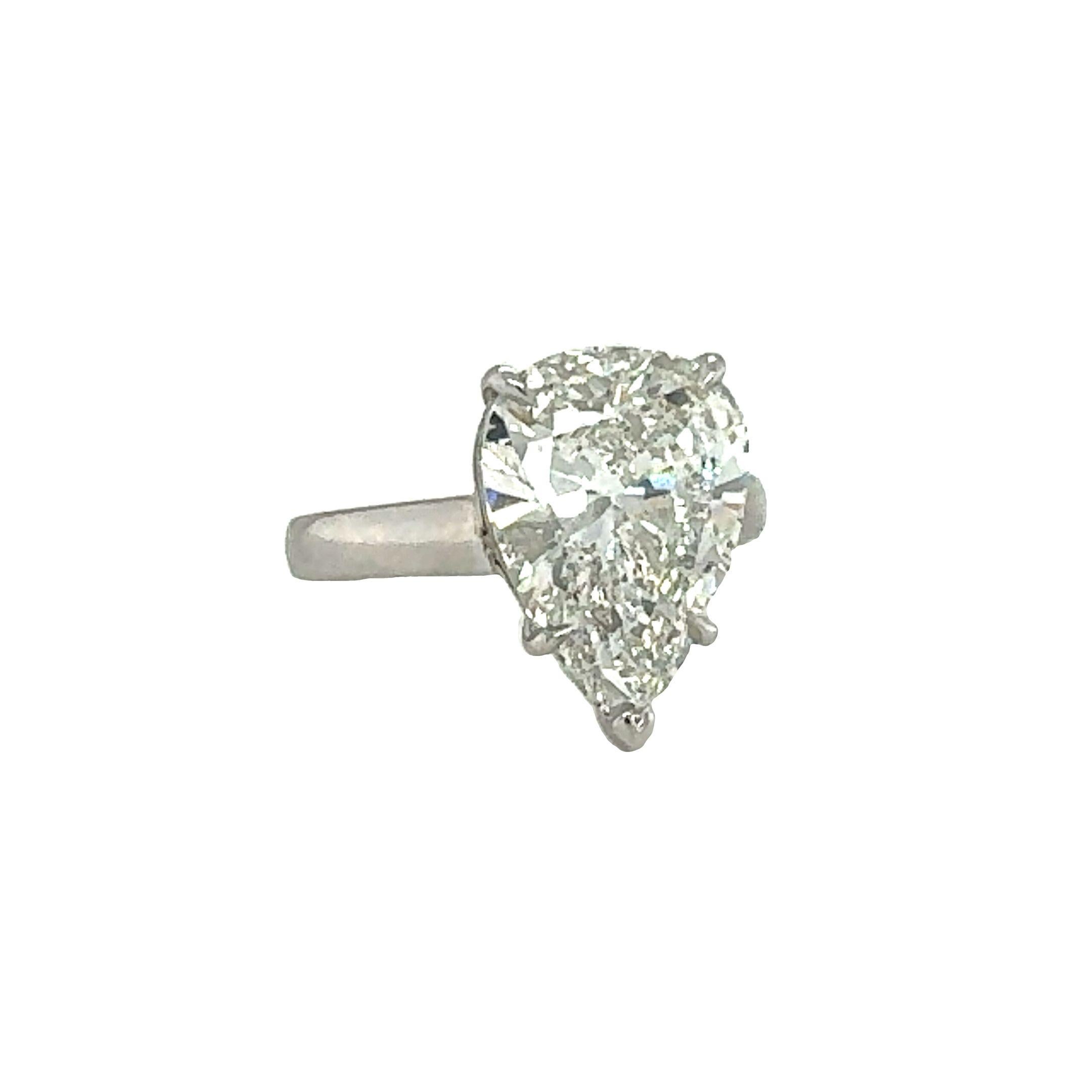 This striking platinum engagement ring showcases a breathtaking 5.31-carat pear brilliant-cut diamond set in classic claw prongs. GIA-certified with J color and I-1 clarity, the diamond is laser-inscribed and radiates a captivating brilliance that