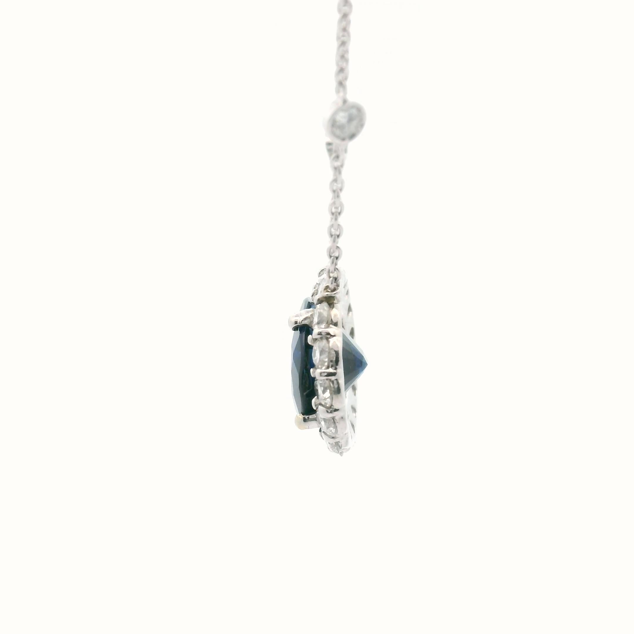 Princess Diana Pendant featuring a 5.38 Oval Cut Natural GIA certified blue sapphire GIA#. This imperial stone is handset in a four-prong setting with an encrusted diamond halo made up of substantial-sized diamonds. The pendant is suspended by a