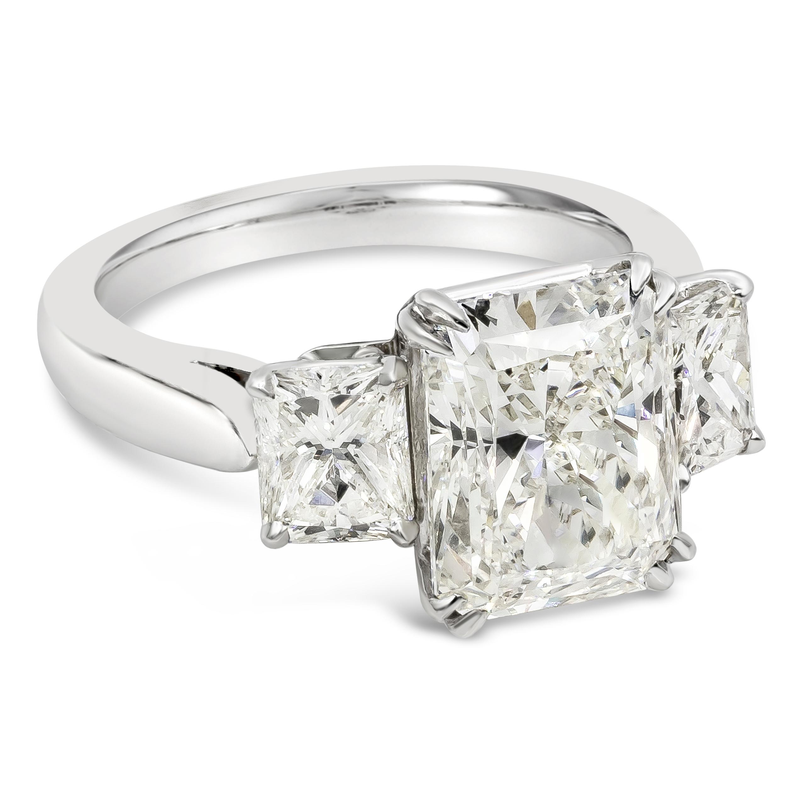 Brilliant and elegantly made three stone engagement ring showcasing a 5.39 carats radiant cut diamond certified by GIA as L color, VS2 in clarity and set in a timeless eight prong basket setting. Flanked by smaller radiant cut diamonds on each sides