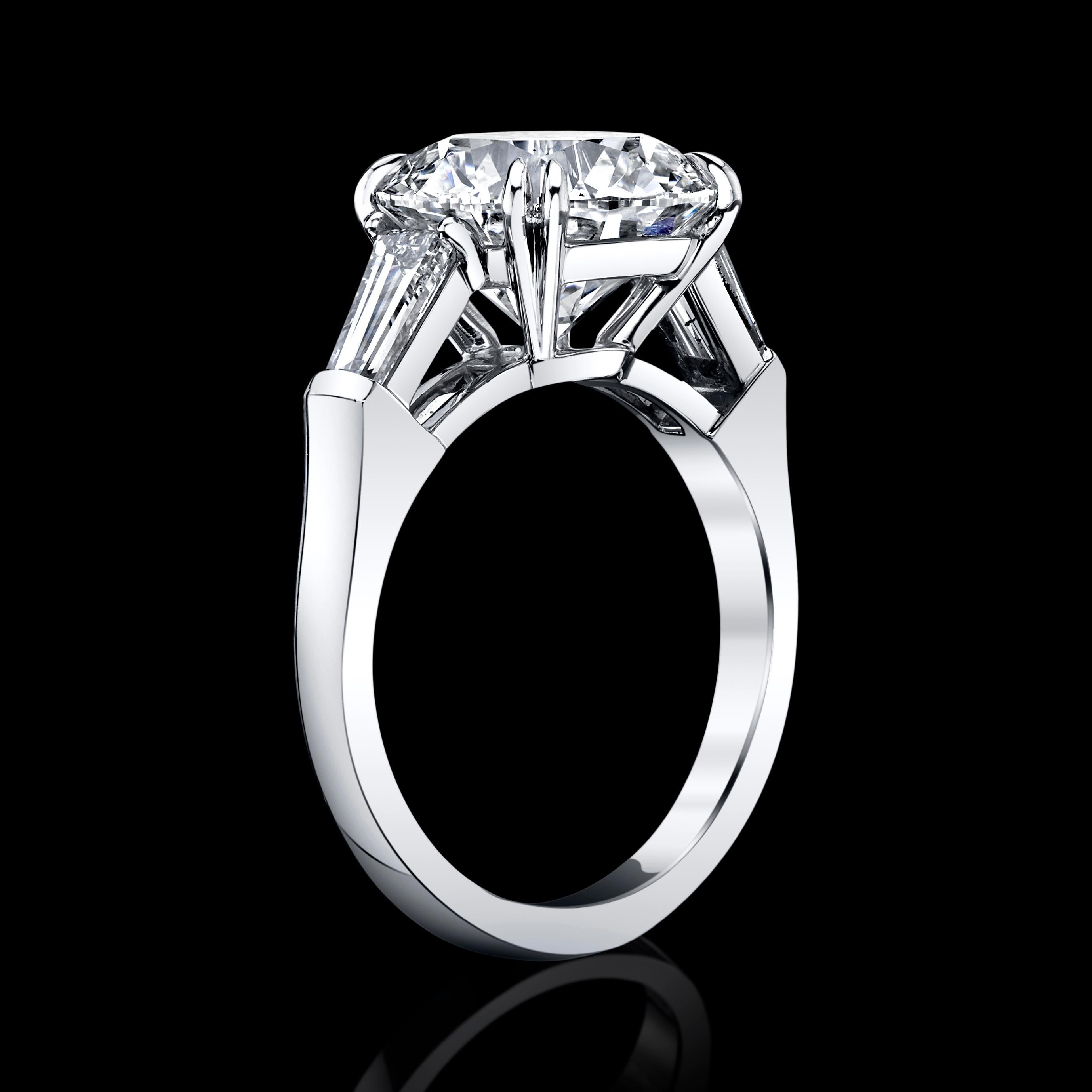 This 5.42ct Round Brilliant Diamond is set in a classic setting platinum ring with two baguettes side diamonds = 0.90cttw
This Diamond is GIA Certified #119228255