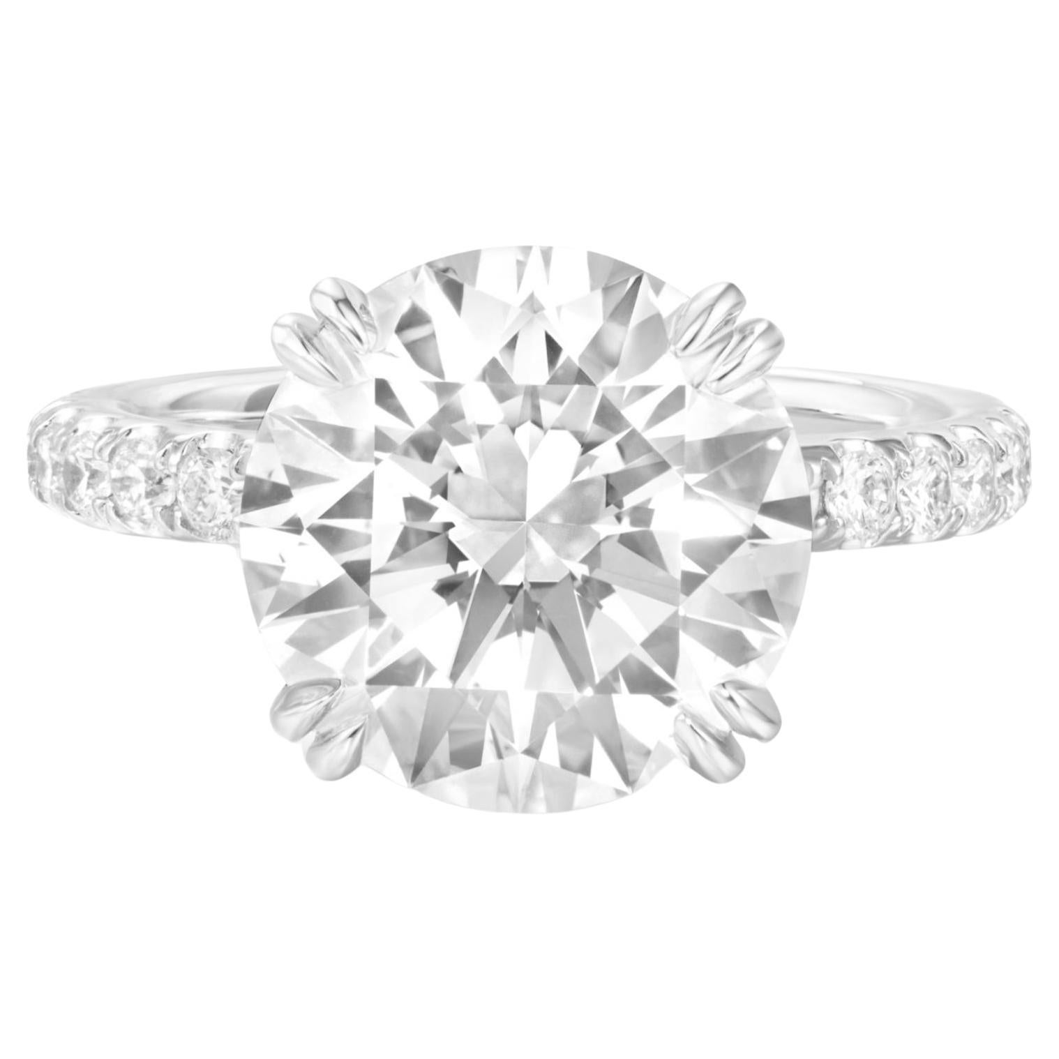 This breathtaking GIA Certified ring showcases a remarkable 5.23 Carat round brilliant diamond, accented by a pavé setting in 18k white gold.

Graded F for it's complete lack of color, this diamond shines with a captivating brilliance.
It's VVS2