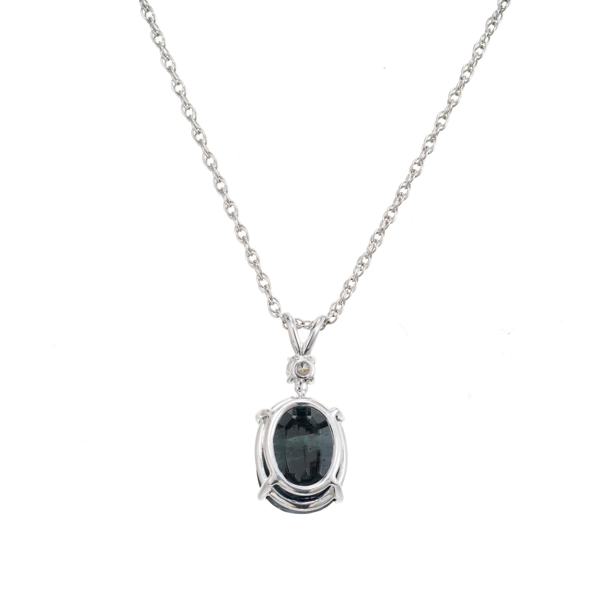 Sapphire and diamond pendant necklace. GIA oval certified dark blue 5.44ct sapphire set in a t simple 4 prong 14k white gold setting accented with one round .8ct diamond set above. The pendant is finished off with a 14k white gold link chain.  The