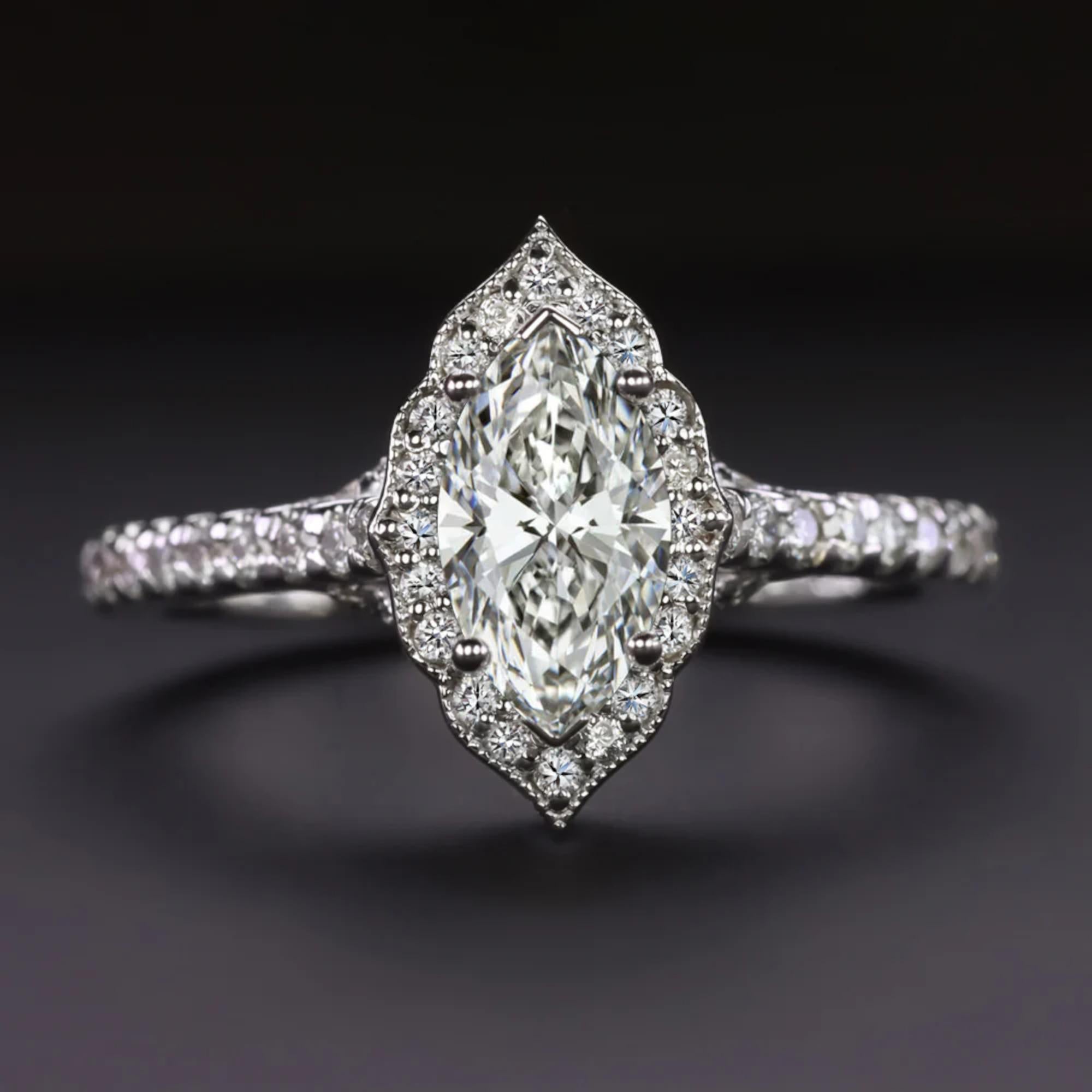 Cette élégante bague en diamant met magnifiquement en valeur un vif diamant taille marquise de 0,55 carat en son centre, encadré par un délicat halo de diamant festonné qui ajoute une touche de charme vintage. Le diamant central, certifié par le