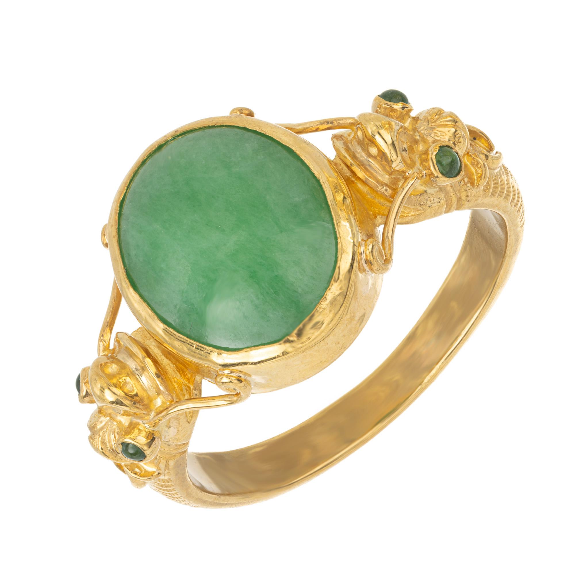 1960's Bright green 5.50 carat translucent GIA certified A grade natural untreated oval jadeite jade set in a handmade ring in 22k yellow gold with intricate filigree and engraving on each side of the ring to resemble a fish. No indications of dye