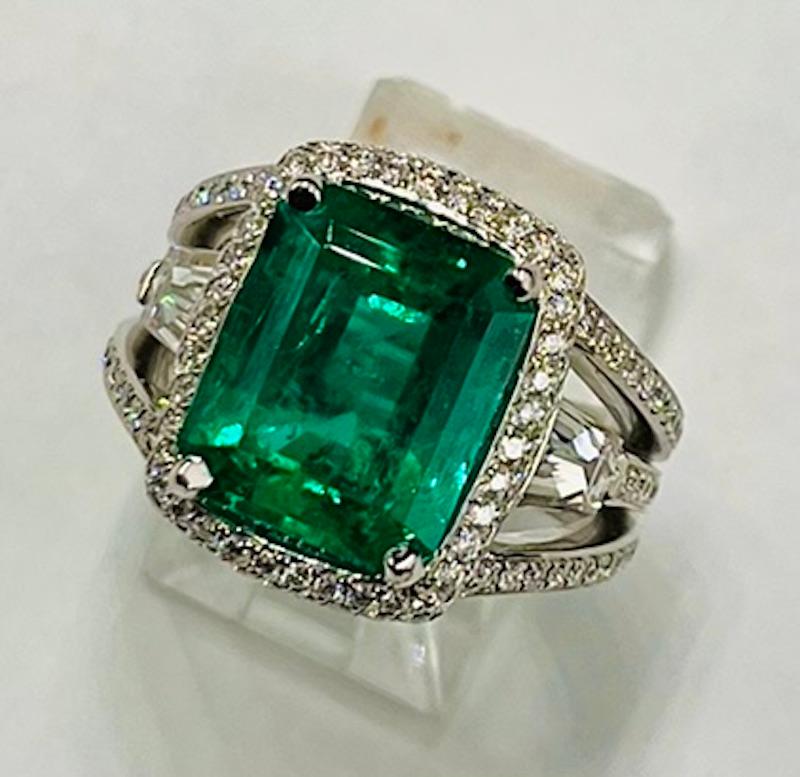 This is a rare large Colombian Emerald. The color saturation is superb while maintaining beautiful transparency.  It is set in a vintage yet classic style ring with a delicate halo and a split shank. This emerald has no milky or foggy