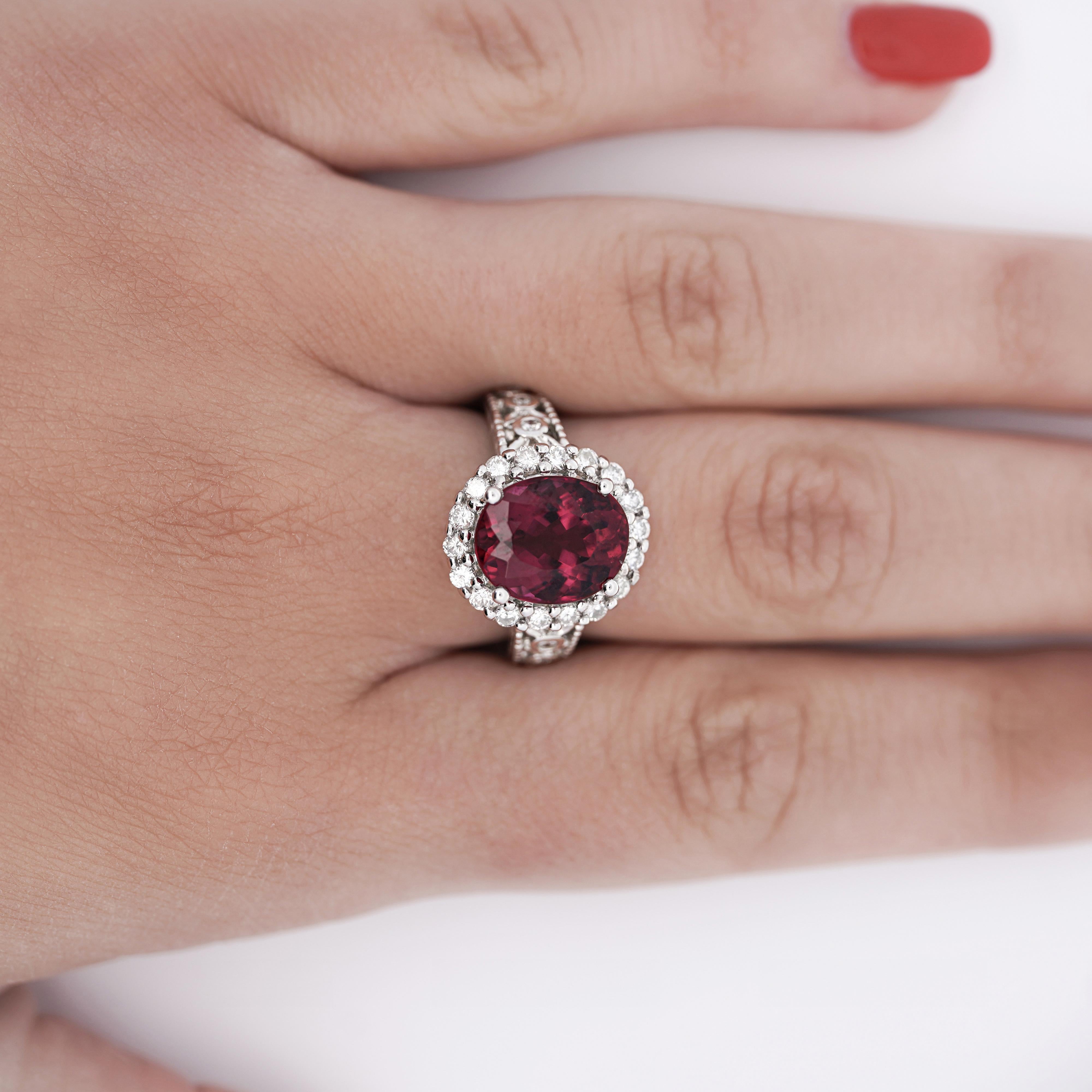 Tormalina rubellite rosso porpora da 5,52 carati con taglio ovale, incorniciata da un'aureola di diamanti bianchi a taglio rotondo, con un peso totale di 0,95 carati. Incastonato in un design a filigrana intagliata.

Dettagli: 
Tipo di articolo: