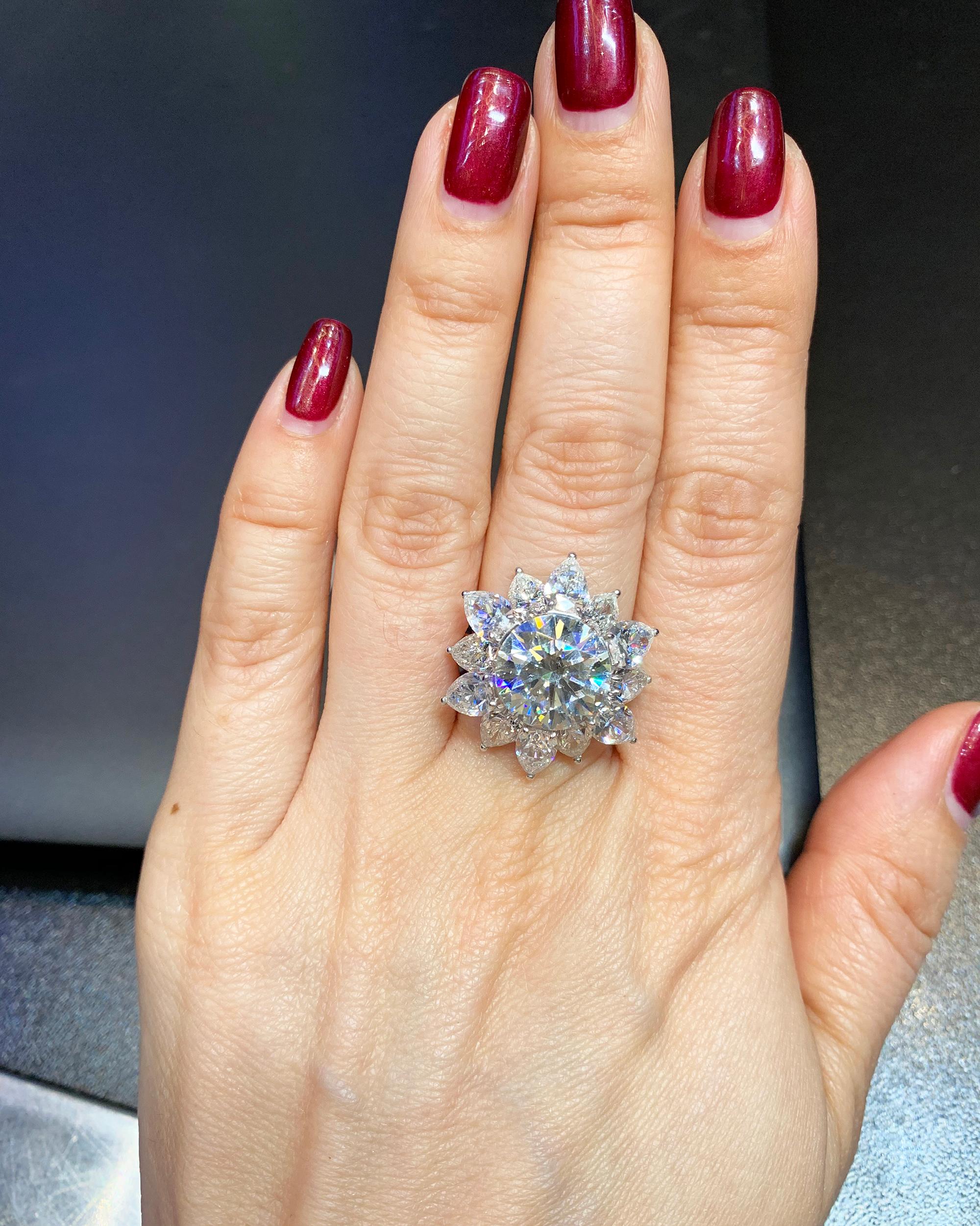 Ein wunderschöner Cocktailring mit einem runden Diamanten von 5,60 Karat, Farbe J, Reinheit SI1. 
Begleitet von dem GIA-Bericht #1165468385. 
Der zentrale Diamant ist umgeben von 12 birnenförmigen Diamanten der Farbe F und der Reinheit VS mit einem