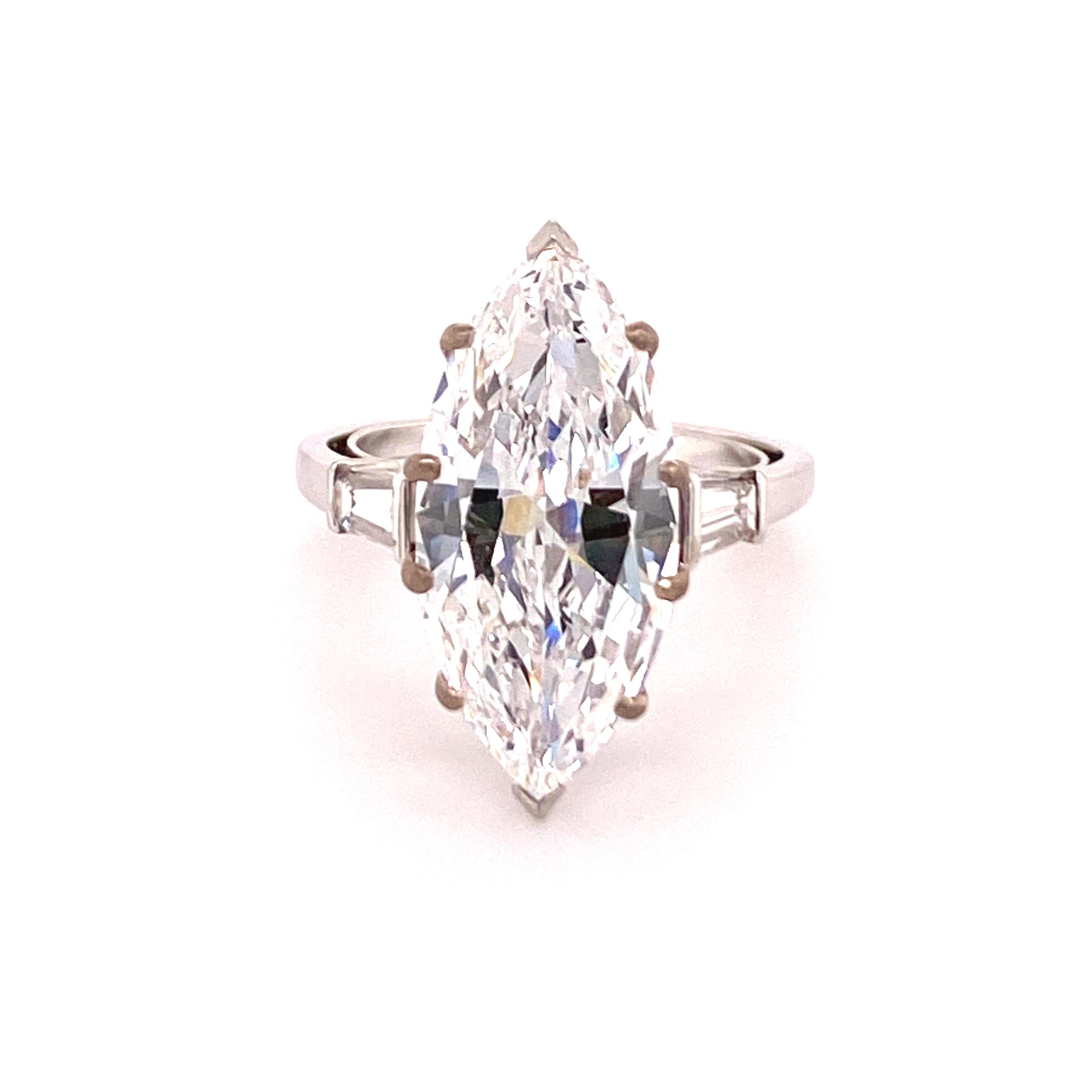 This superb handcrafted ring in platinum 950 features a stunning marquise-cut diamond of 5.60 carats, D colour and vvs2 clarity. 
Accented by two tapered baguette-cut diamonds of F/G colour and vs clarity with a total weight of approximately 0.40