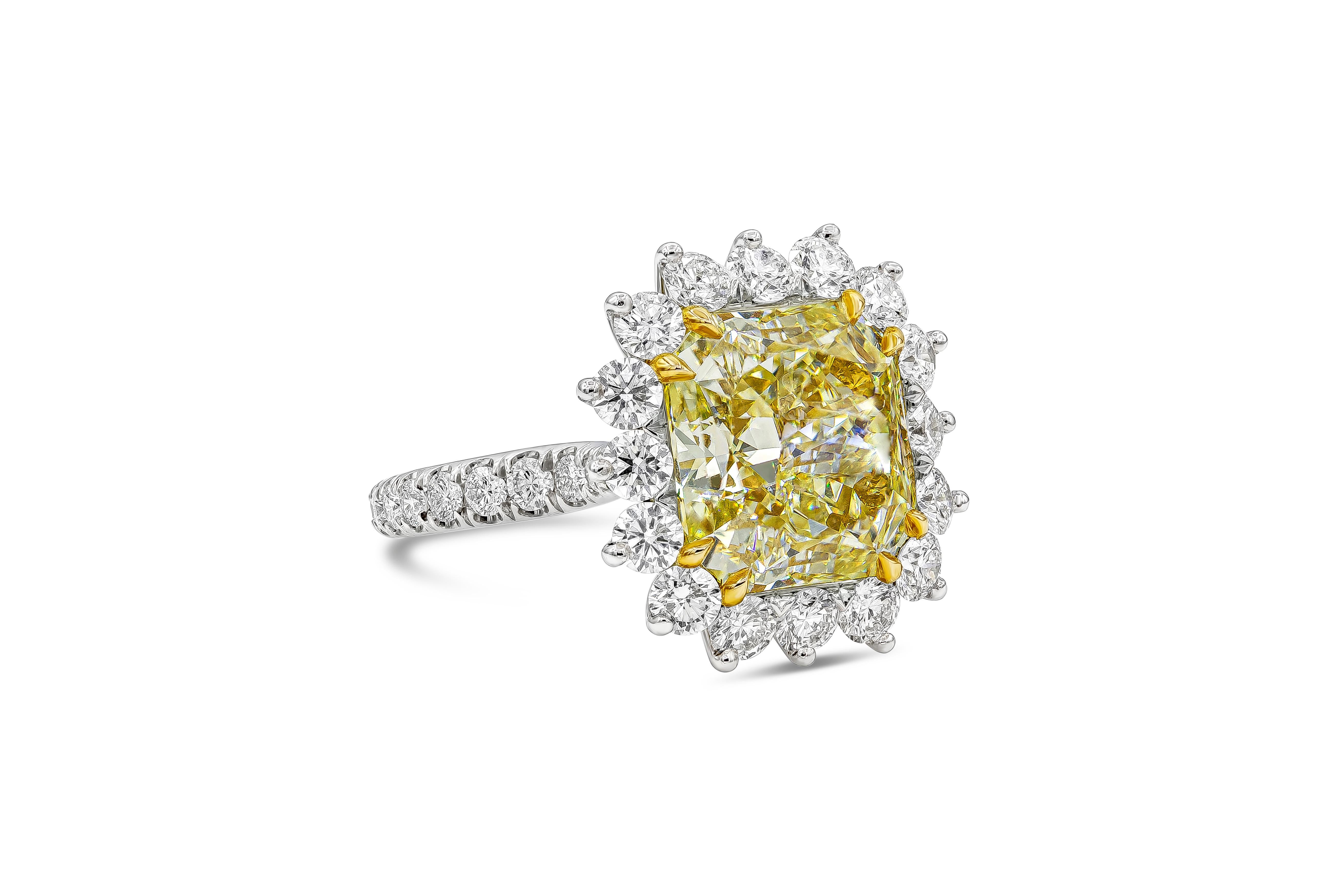 Well crafted and color rich halo engagement ring showcasing a vibrant 5.66 carat radiant cut diamond certified by GIA as fancy yellow, VS1 in clarity, set in an eight prong 18k yellow gold setting. Accenting the center stone is a row of 16 pieces