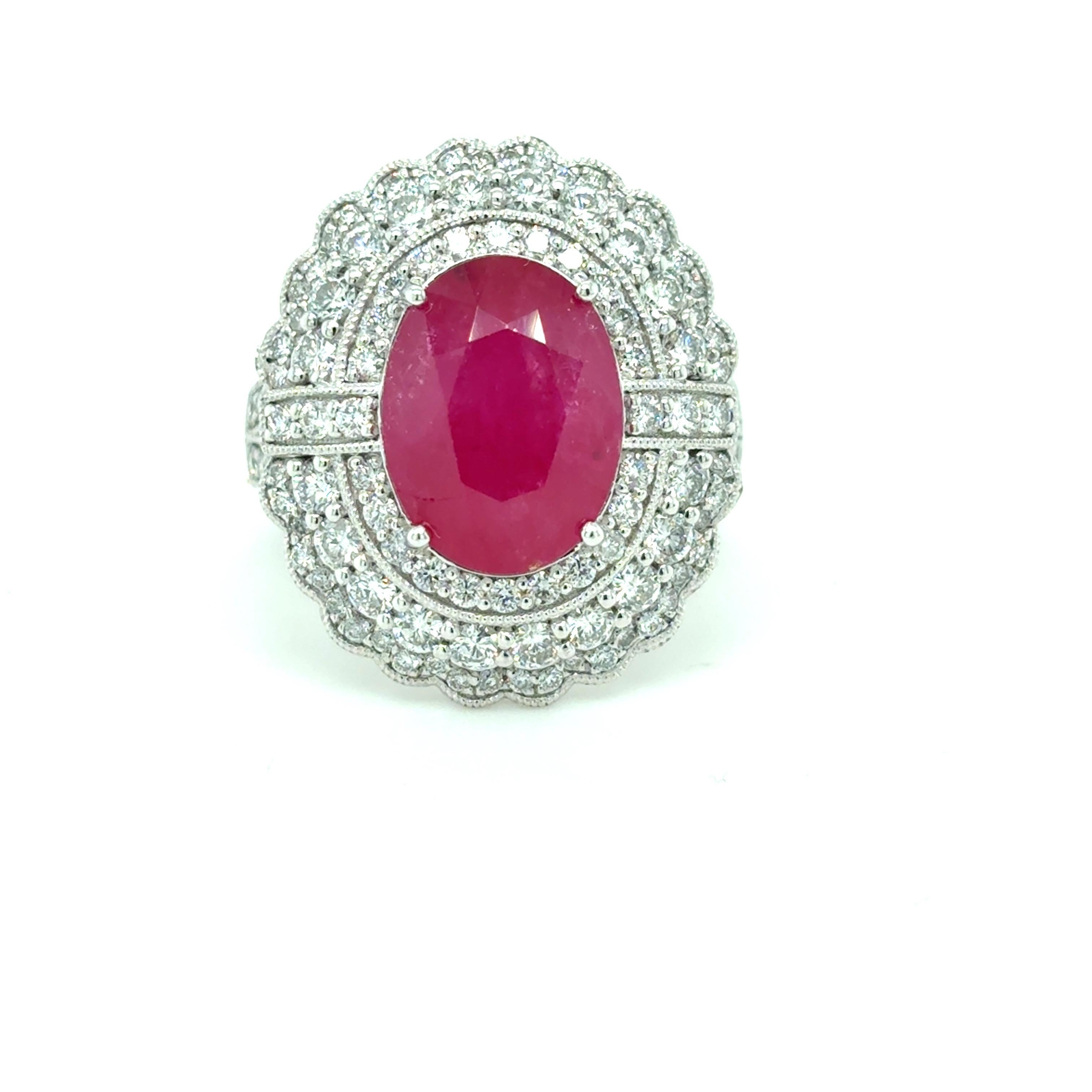 Anello con rubino birmano da 5,69 carati certificato GIA, con un rubino dal taglio ovale circondato da tre file di splendidi diamanti bianchi per un totale di 1,38 carati. Splendidamente realizzato in platino con un'elegante galleria sottostante,