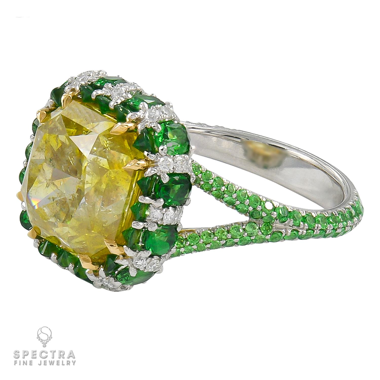 A cocktail ring adorned with a fancy deep yellow diamond, square radiant-cut, weighing a total of 5.87 carats.
The center diamond is certified by the GIA.
It's accented by green tsavorite gemstones and white diamonds. 
Metal is platinum, gross