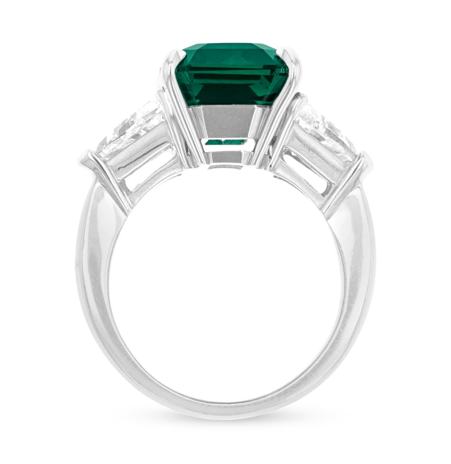 Showcasing a 5.93 carat green emerald vivid green of exceptional quality!!

F color and VS1 clarity (GIA Certified), this elegant engagement ring is crafted in 18K white gold. The center stone’s clean lines and radiant fire are complemented by