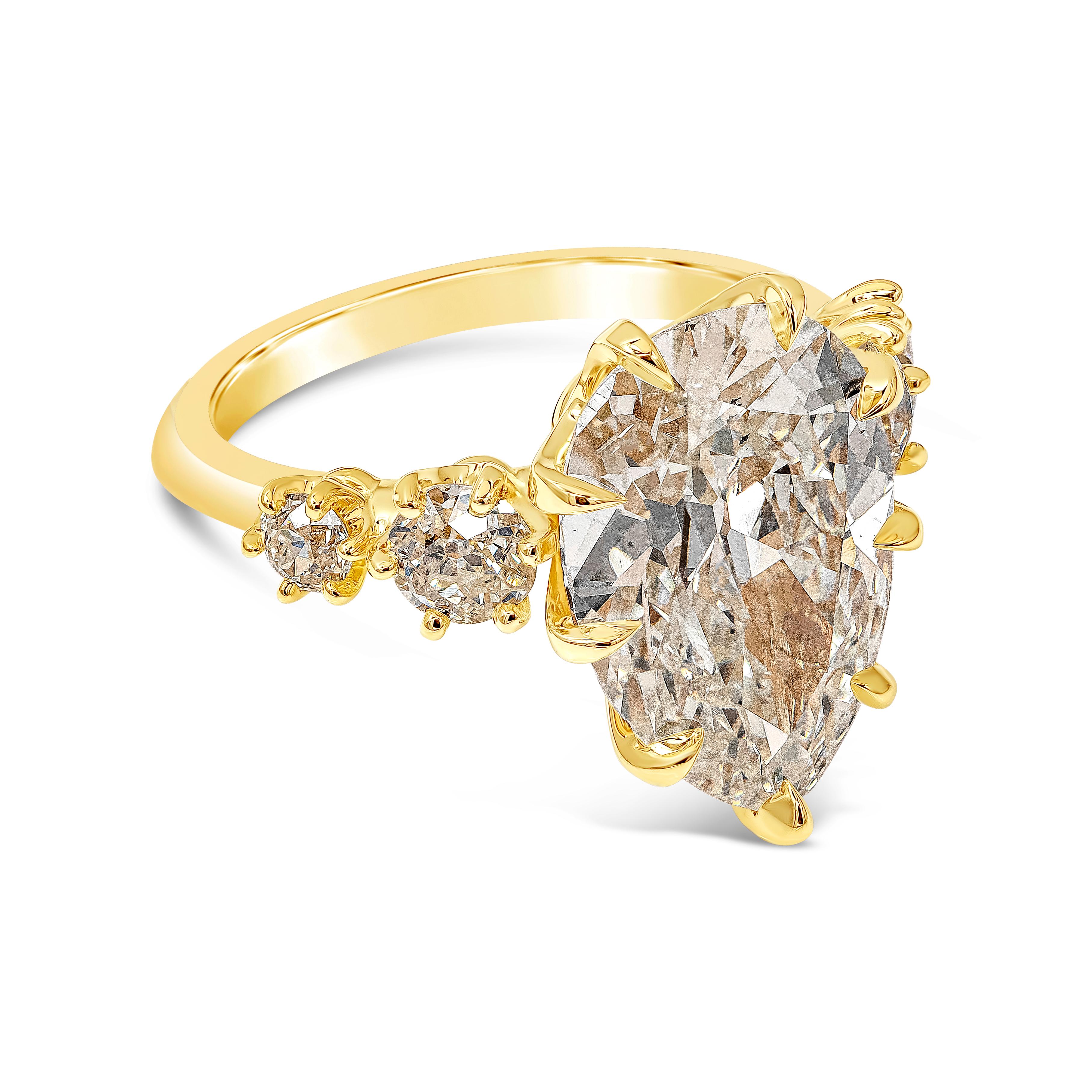 An antique-style engagement ring showcasing a 5.95 carat pear shape diamond certified by GIA as L color, SI1 in clarity. Flanked by 4 old-mine cut diamonds on either side weighing 0.83 carats total. Set in a handcrafted 18k yellow gold basket. Size